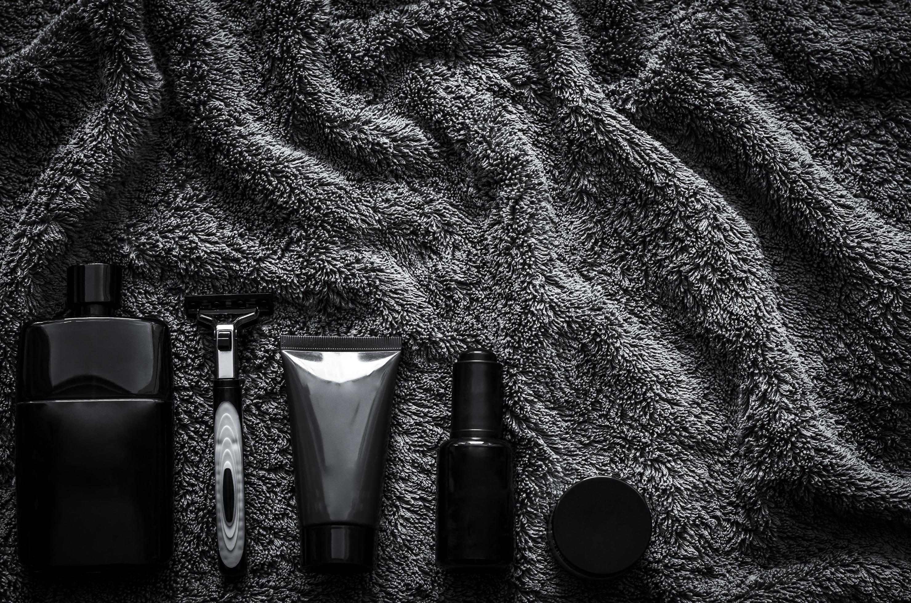 Men toiletries in modern lifestyle on dark towel background for minimalist flat lay black concept. Stock Free