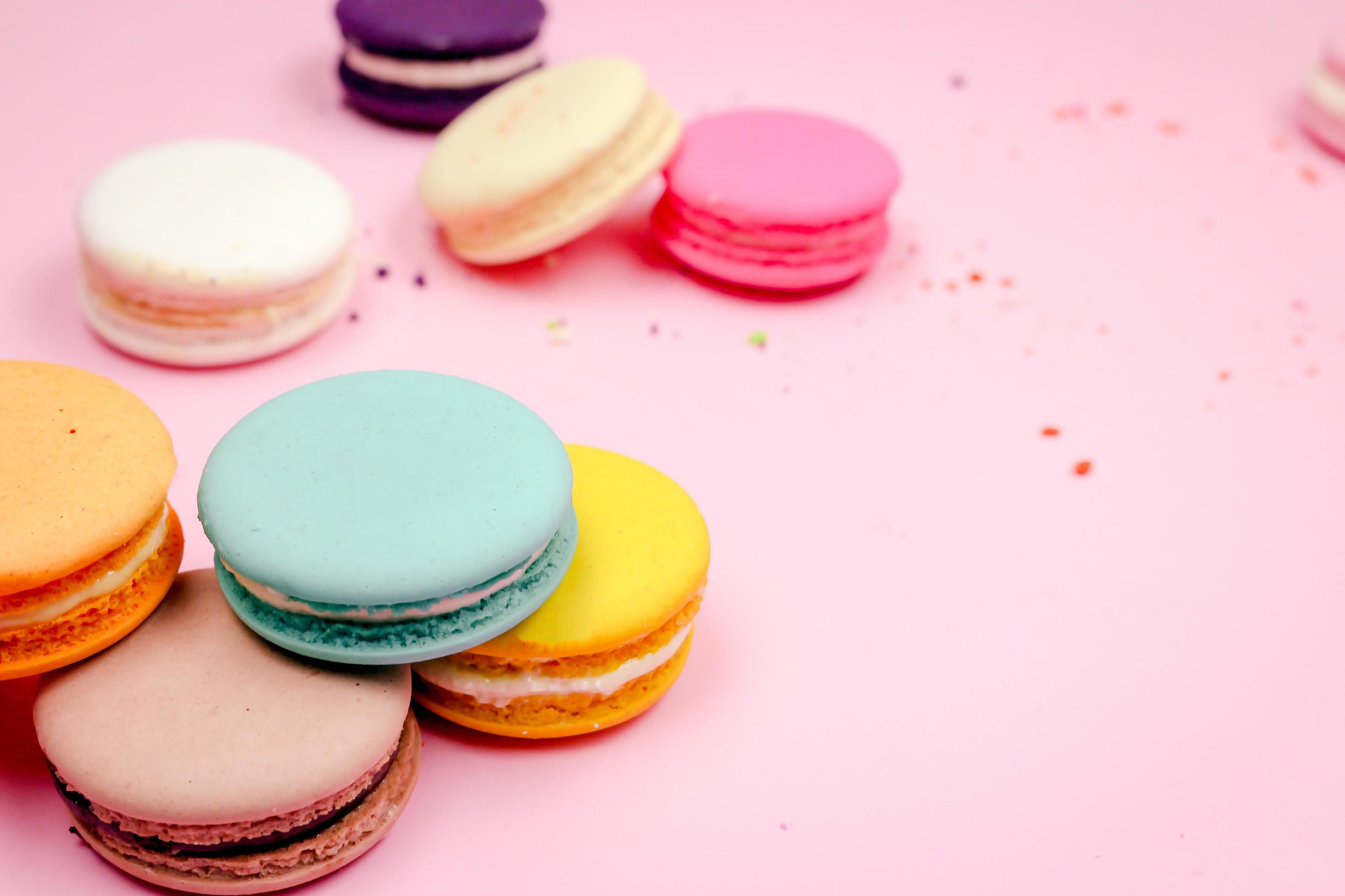 Colorful french macarons macaroons cake, delicious sweet dessert on a pink background with copyspace, food background concept. Stock Free