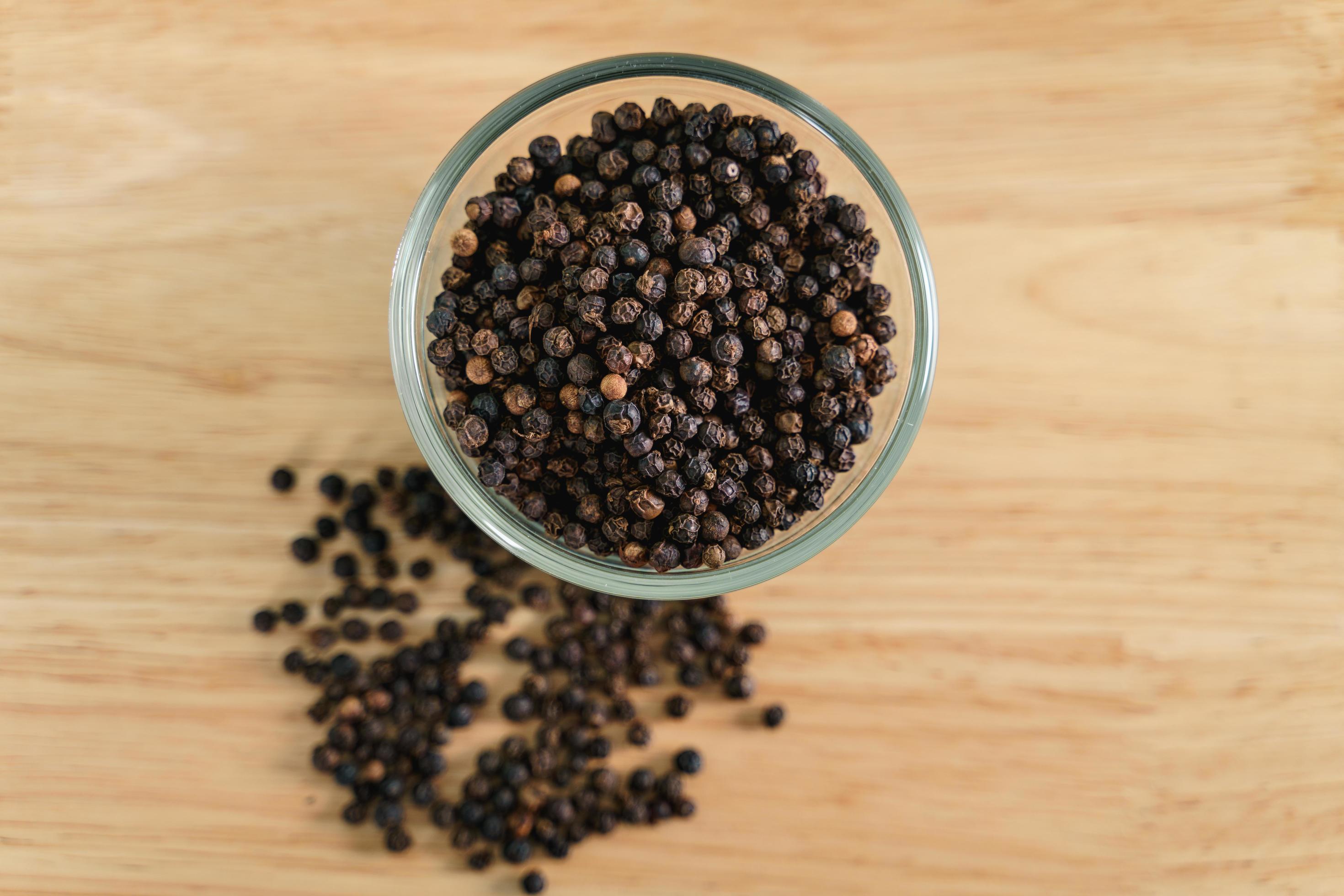 Black pepper in a glass bowl on the wooden table. food, spice, seasoning Concept. Stock Free