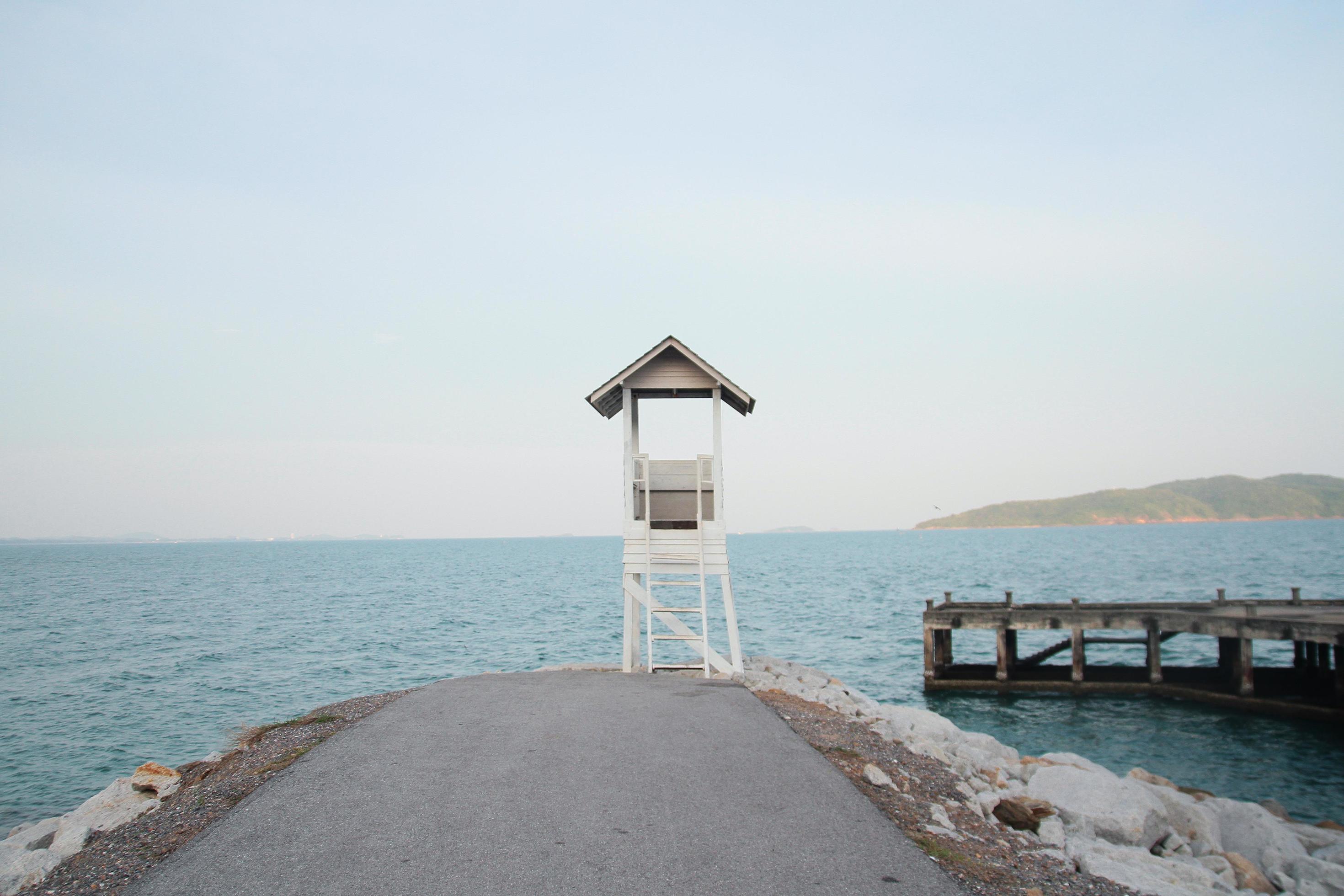 White Lifeguard tower and old wooden bridge with Seascape view on the beach in Thailand Stock Free