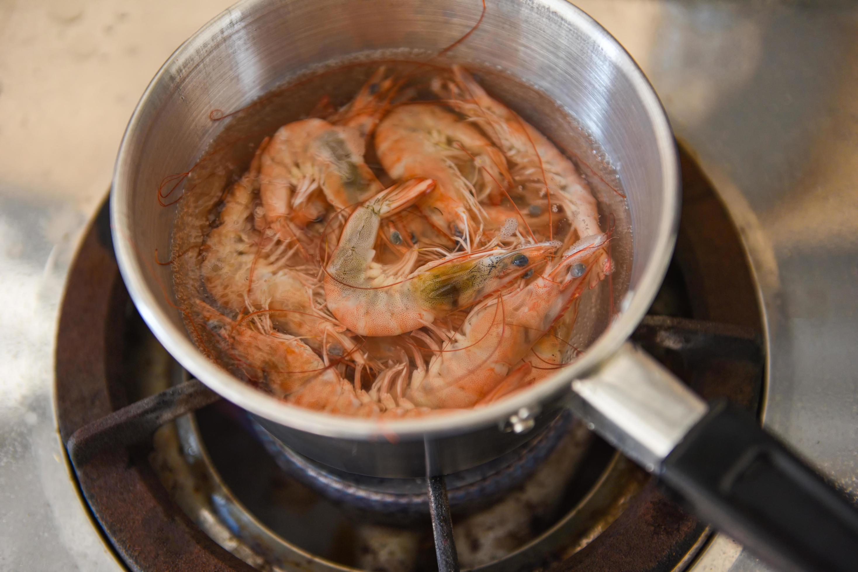 Boiled shrimps in a hot pot on the stove, shrimp prawn cooking menu food concept Stock Free