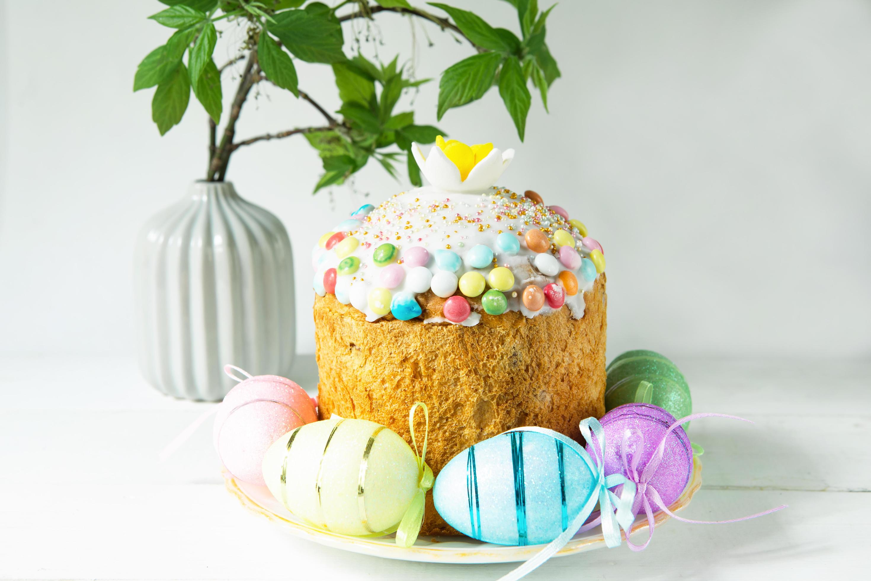 Easter cake with painted eggs on a platter in a gray interior. Traditional festive food Stock Free