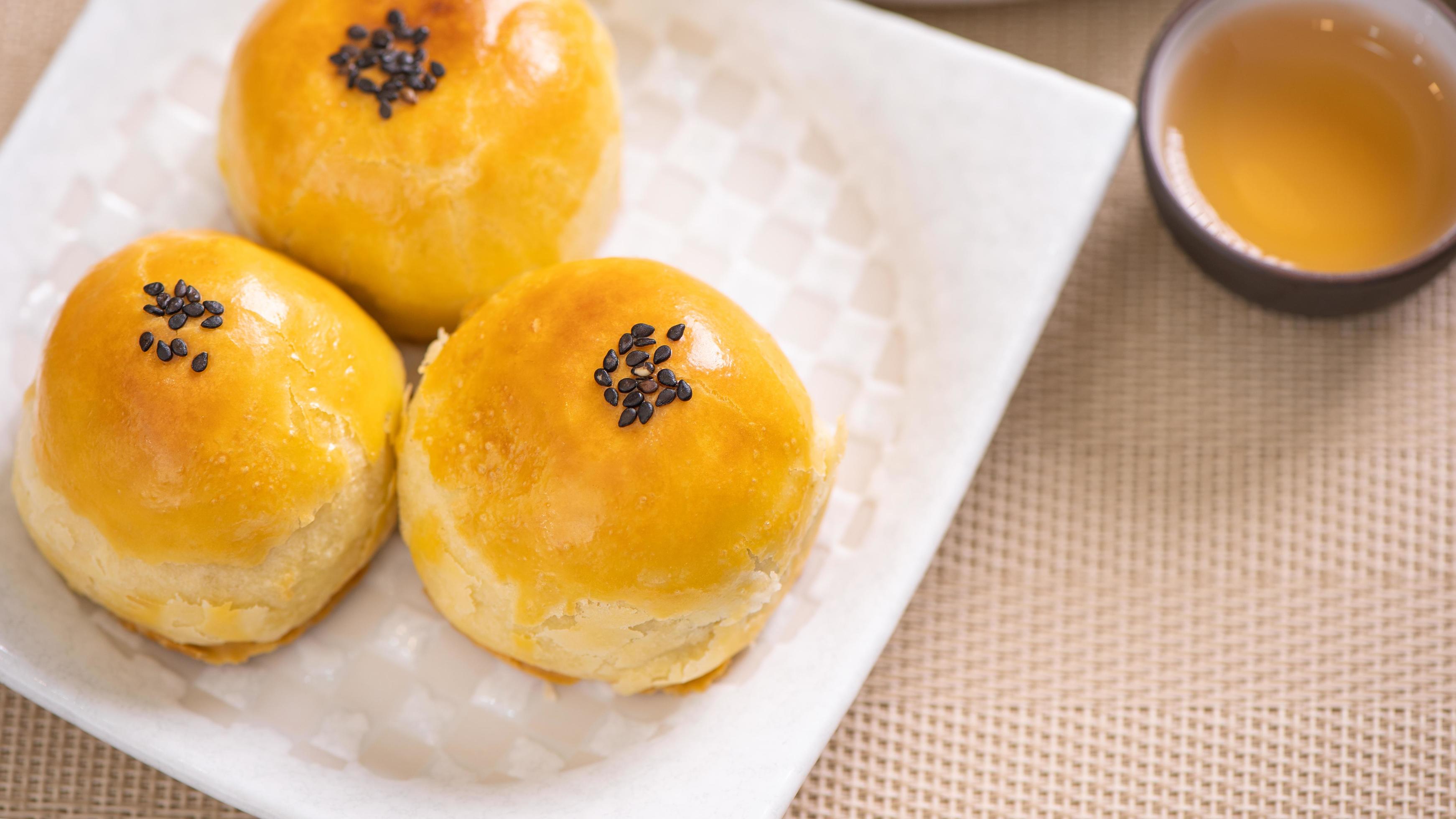 Tasty baked egg yolk pastry moon cake for Mid-Autumn Festival on bright wooden table background. Chinese festive food concept, close up, copy space. Stock Free