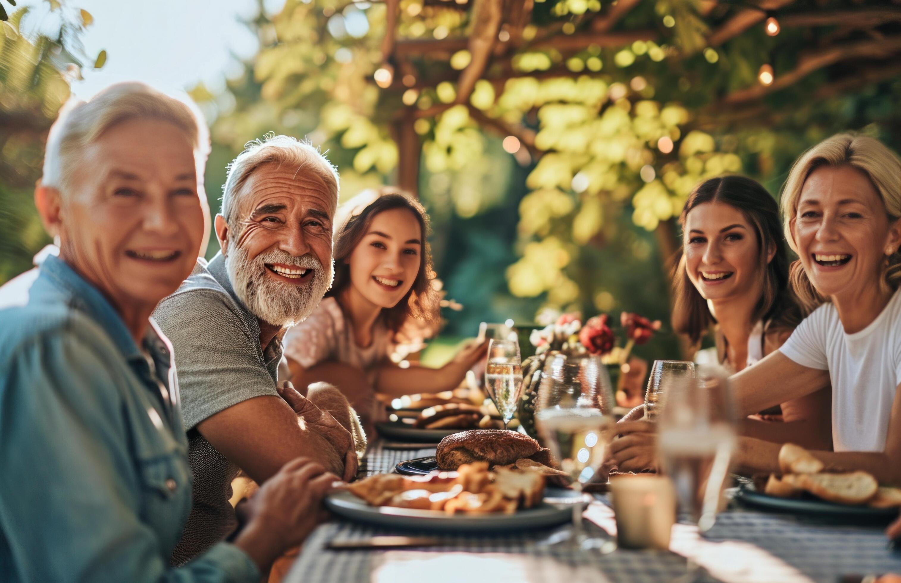 AI generated family smiling for the camera at a family table outdoors Stock Free