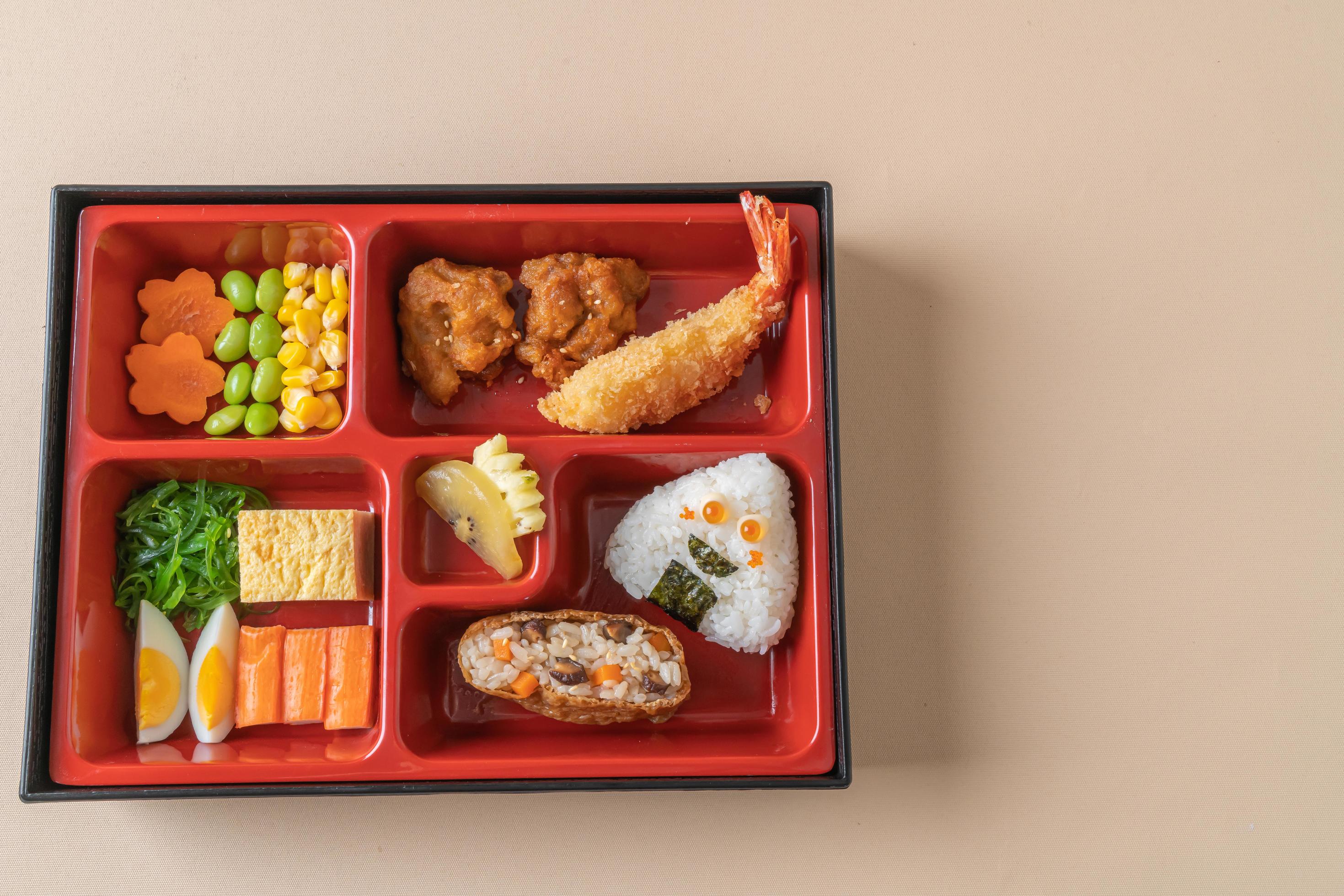 Inari sushi rice wrapped in dried tofu with fried shrimp and fried chicken in bento set – Japanese food style Stock Free