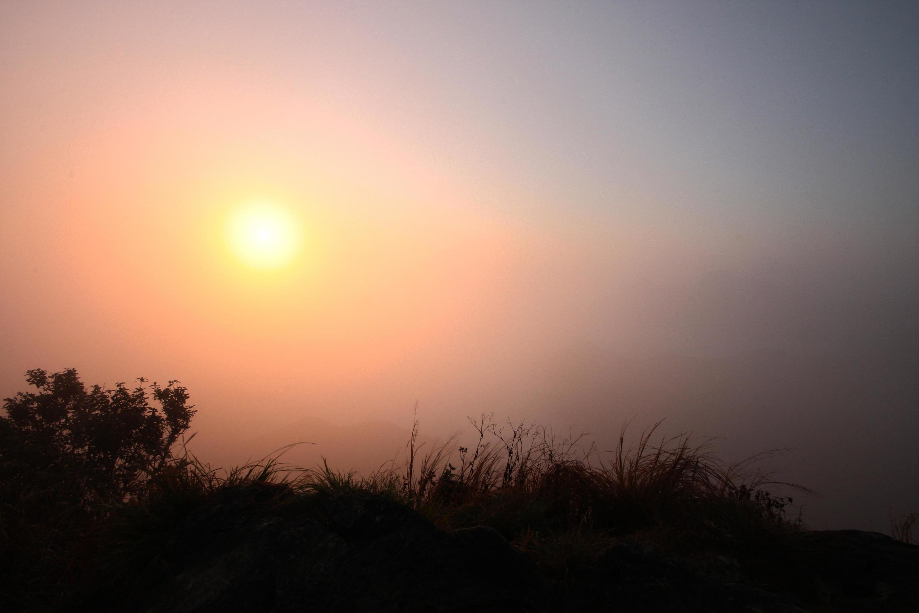 Beautiful silhouette landscape valley of mountain with fog and mist in winter of sunrise shining on the sky Stock Free