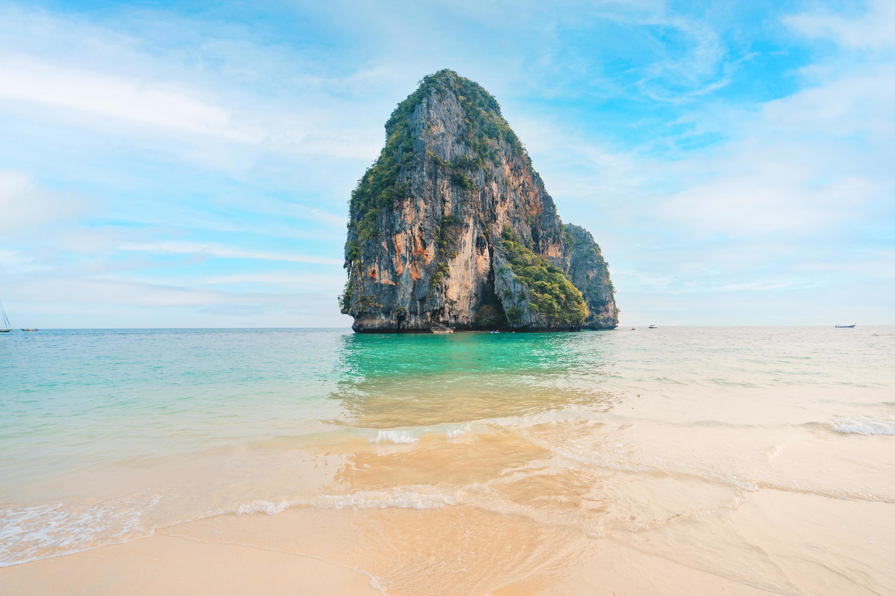 sea, beach and rocky mountains in tropical evening Stock Free