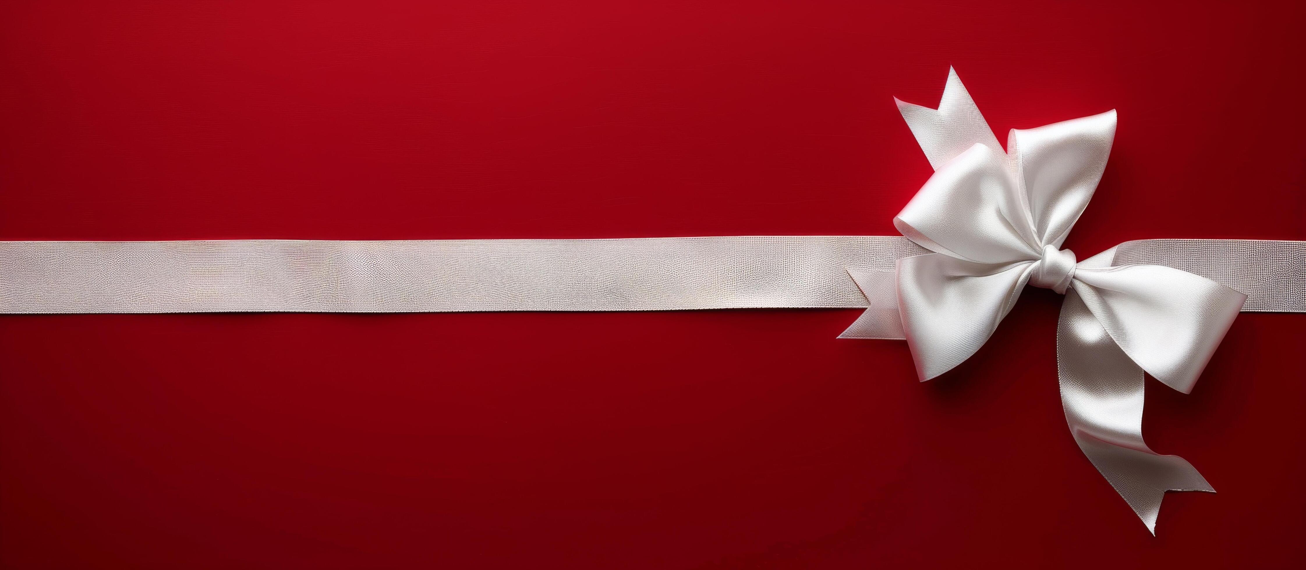 White Satin Bow on Red Background With Silver Ribbon Stock Free