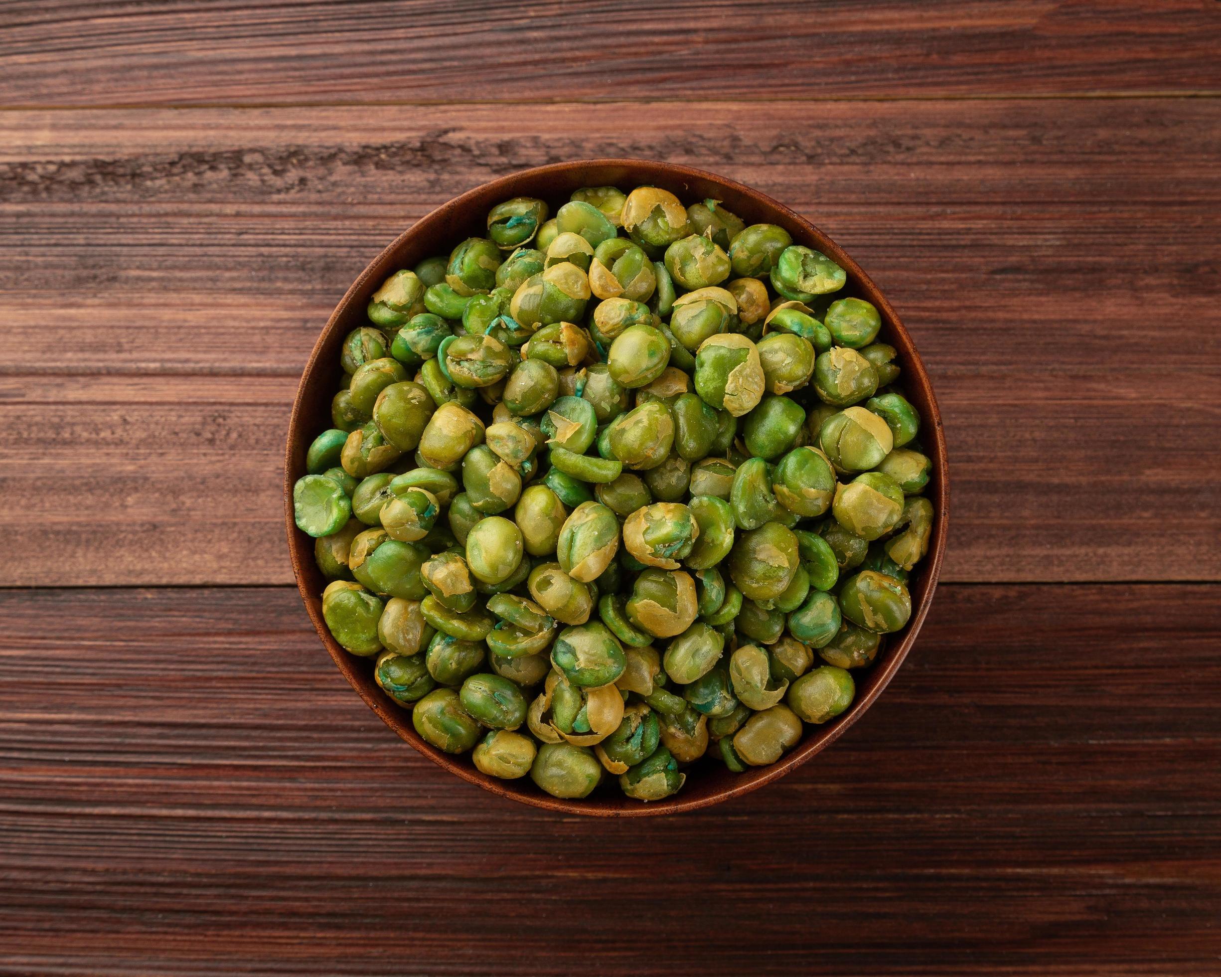 Salted green peas in wooden bowl on the table, Healthy snack, Vegetarian food Stock Free