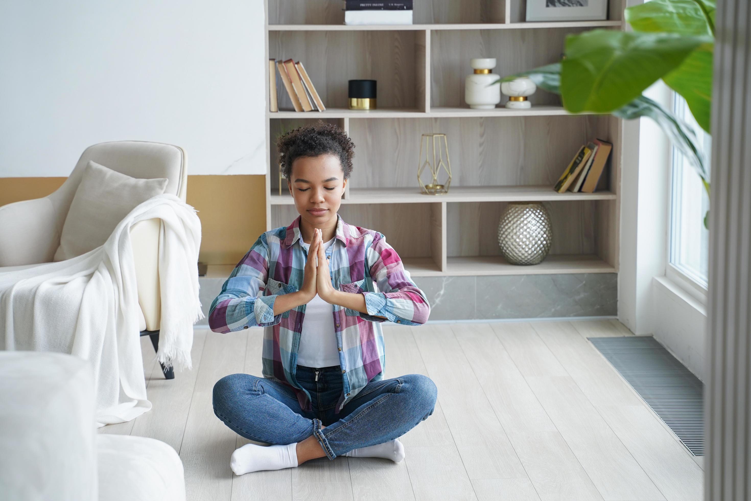 Young teen african american girl practice yoga in lotus pose at home. Healthy lifestyle, meditation Stock Free