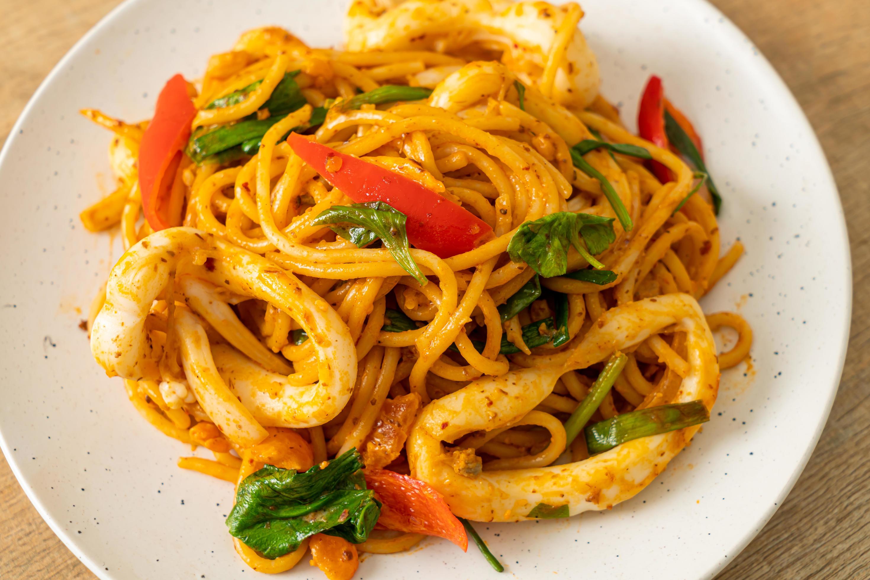 Stir-fried spaghetti with salted egg and squid – fusion food style Stock Free