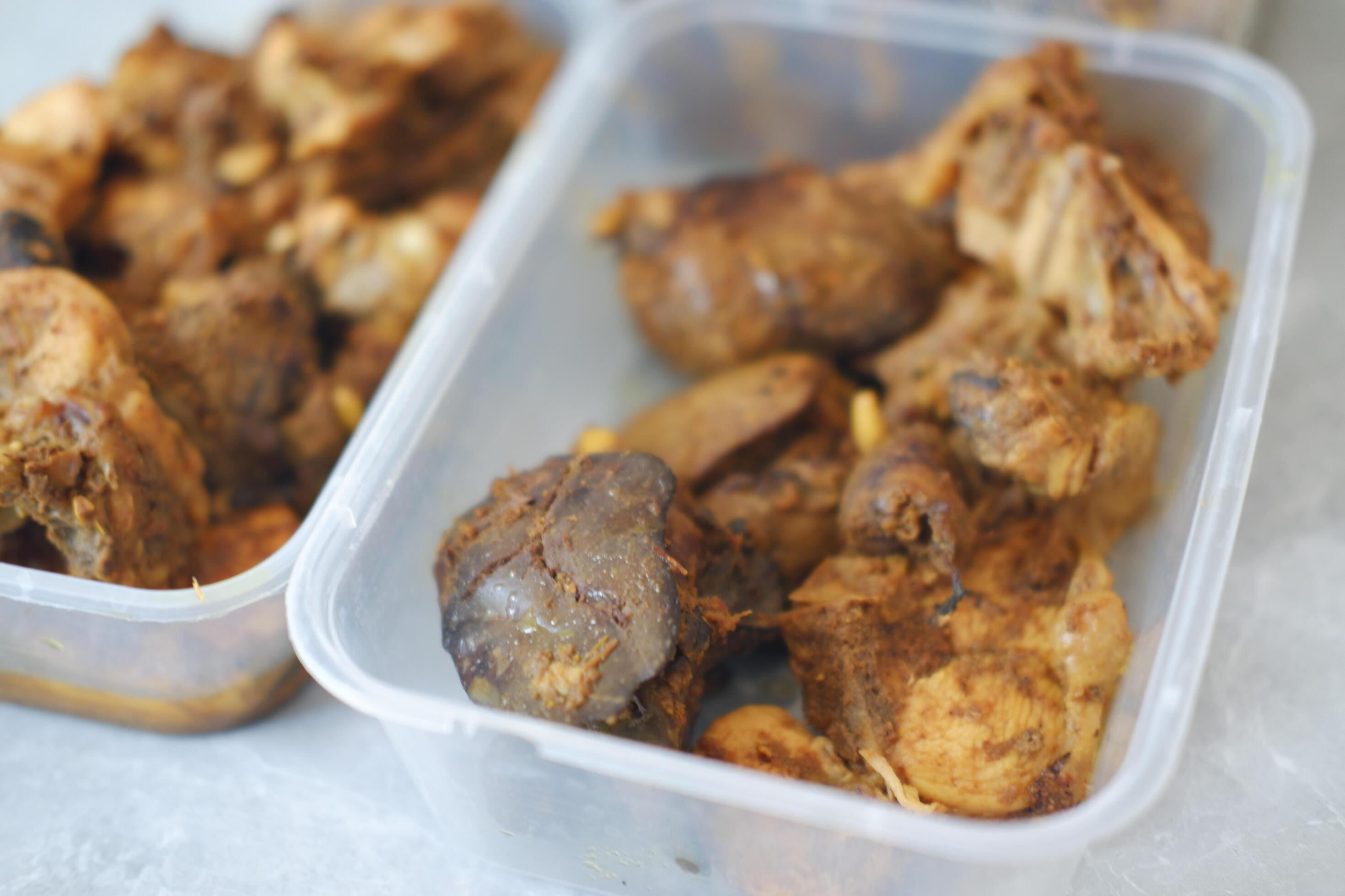 Two plastic containers filled with spiced chicken Stock Free