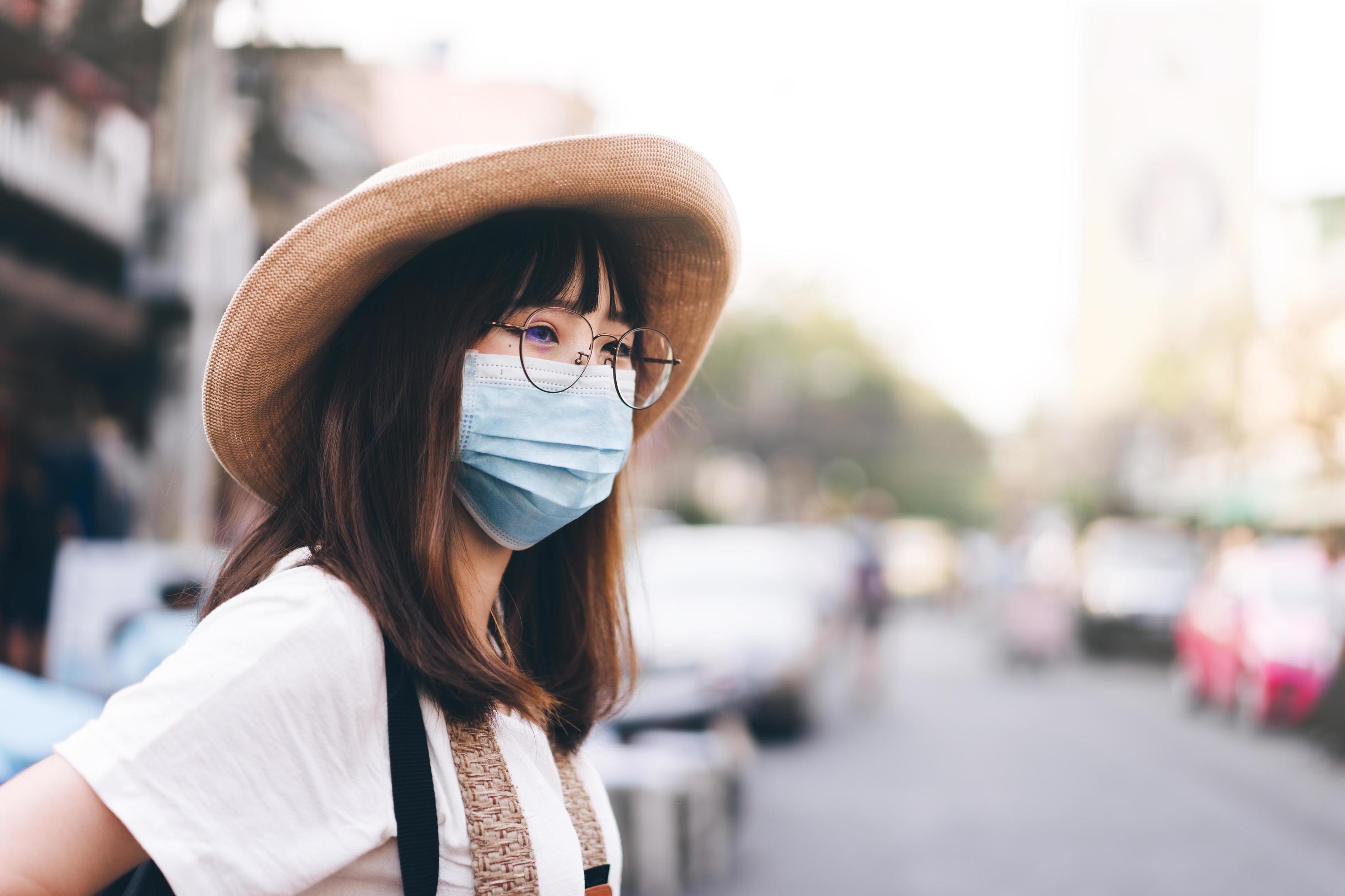 Young asian traveller glasses girl with hat and mask protect virus and new normal lifestyle Stock Free