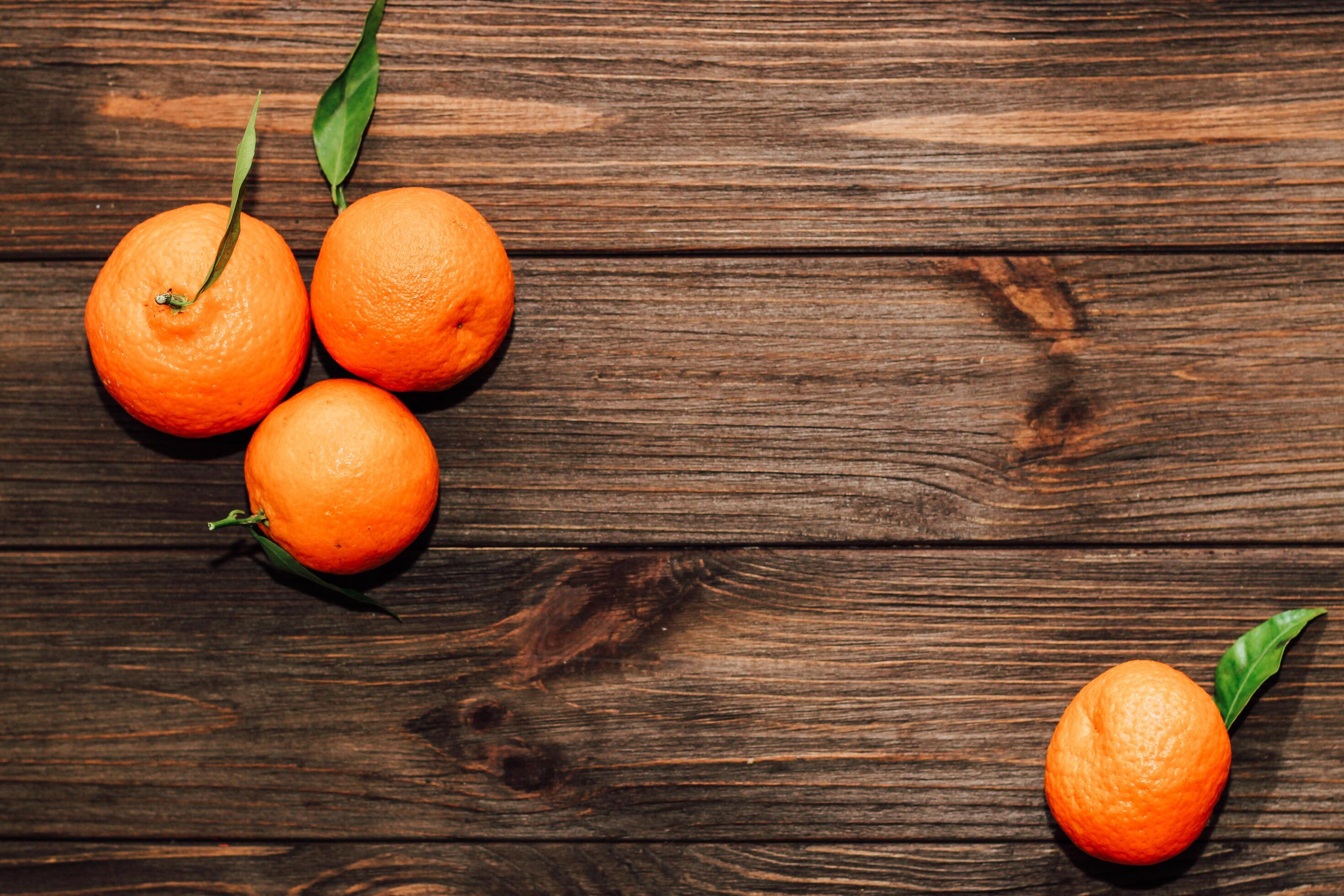 Tangerines on the background of a wooden brown table with boards Stock Free