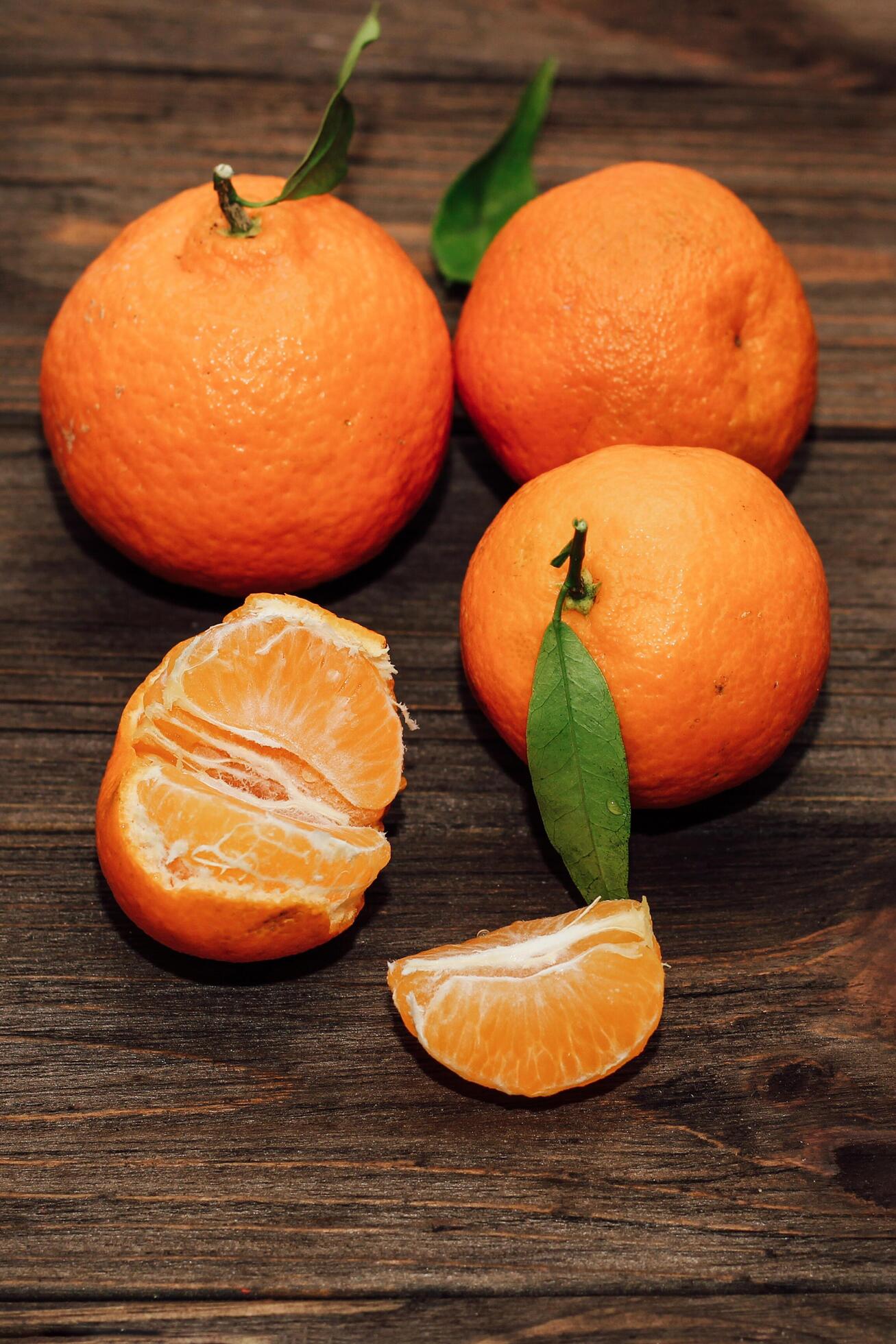 Tangerines on the background of a wooden brown table with boards Stock Free