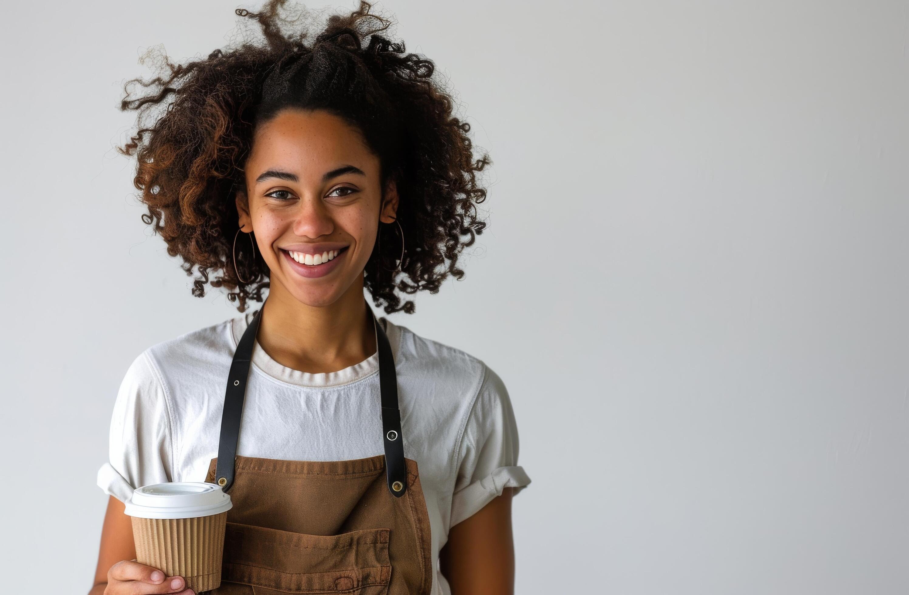 Smiling Woman Holding a Coffee Cup in a White Shirt and Black Apron Stock Free