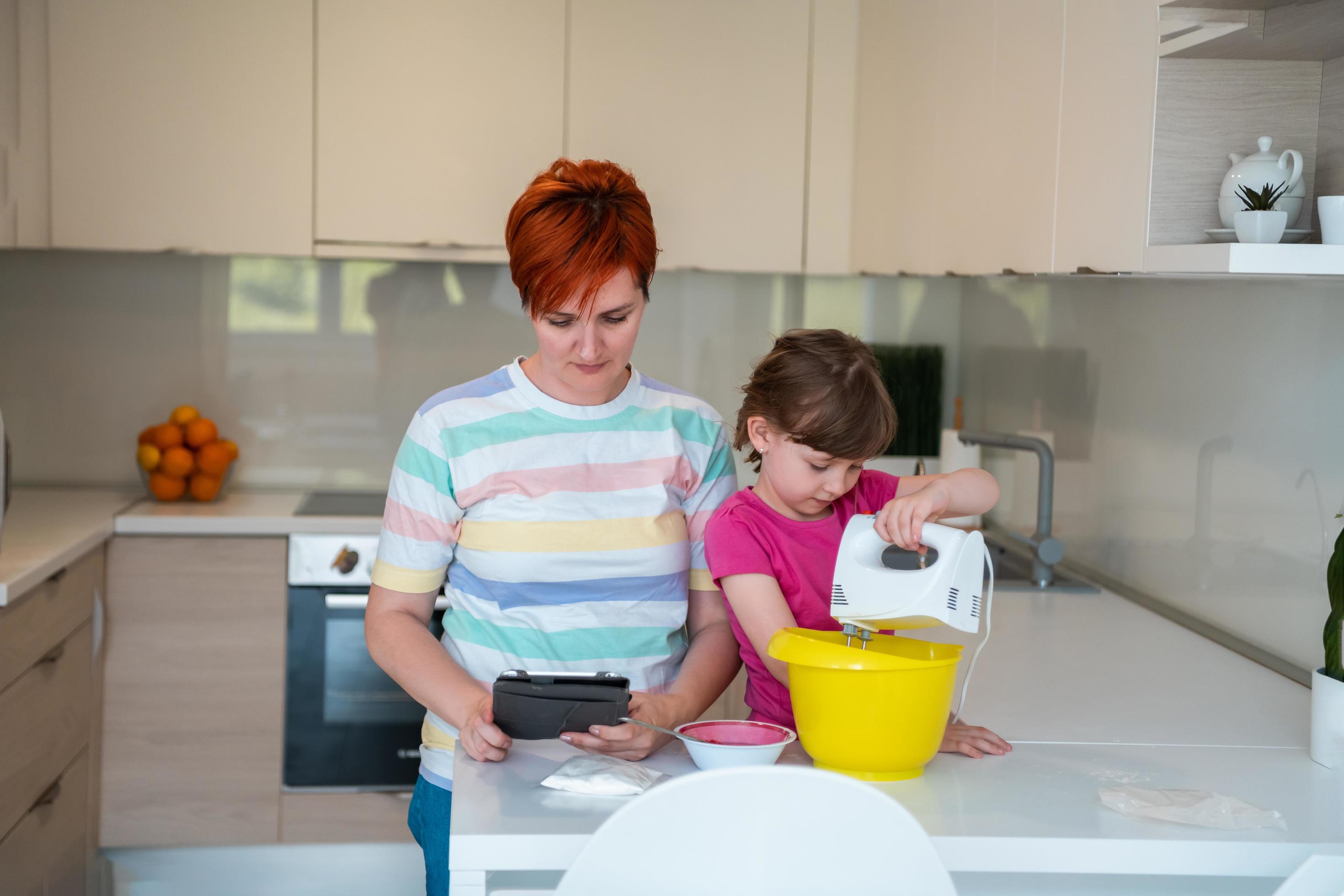 little girl and mom making tastz cake in kithen family having fun at home Stock Free