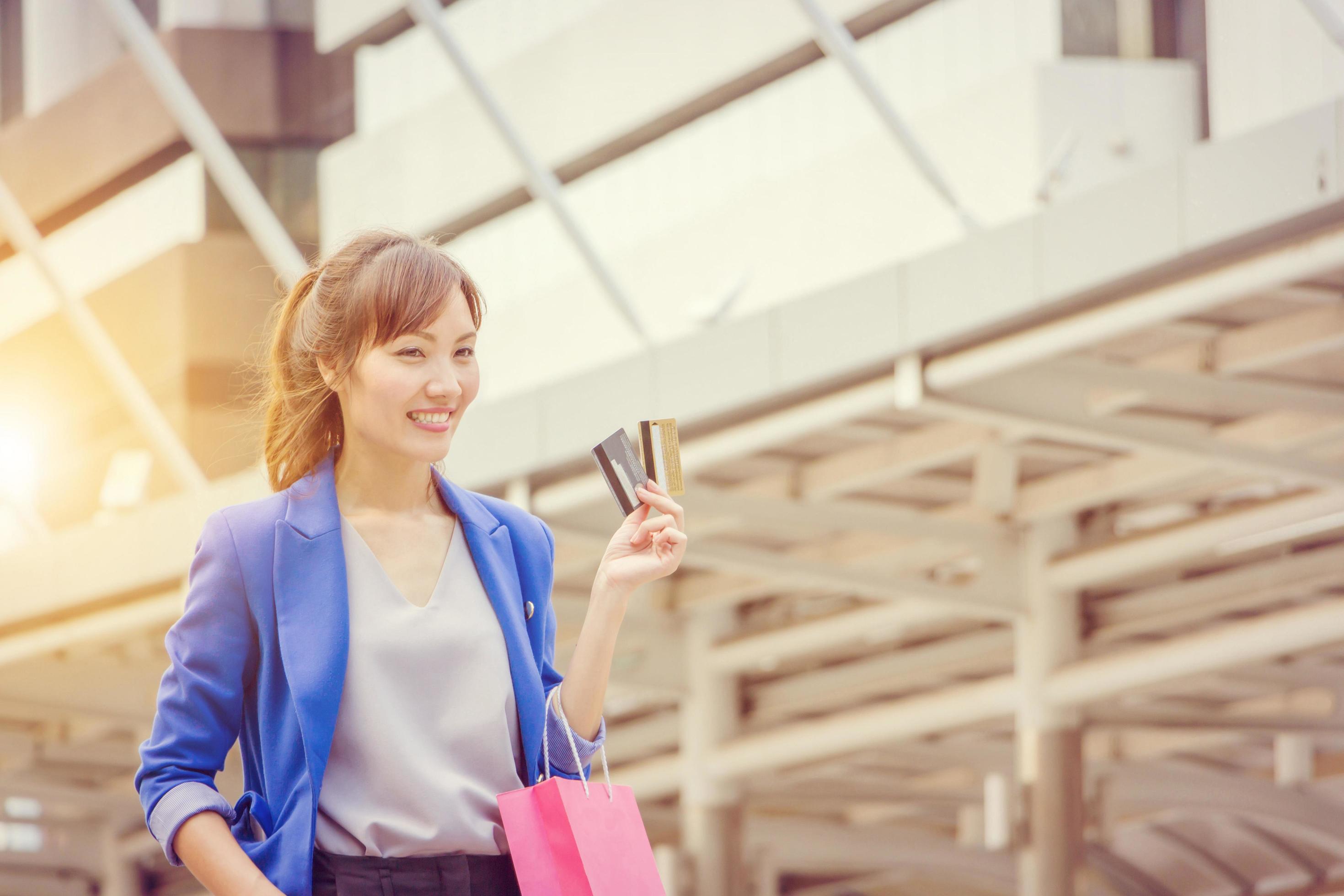 young woman carrying shopping bags while walking along the street. Happy Life Style Concept. Stock Free