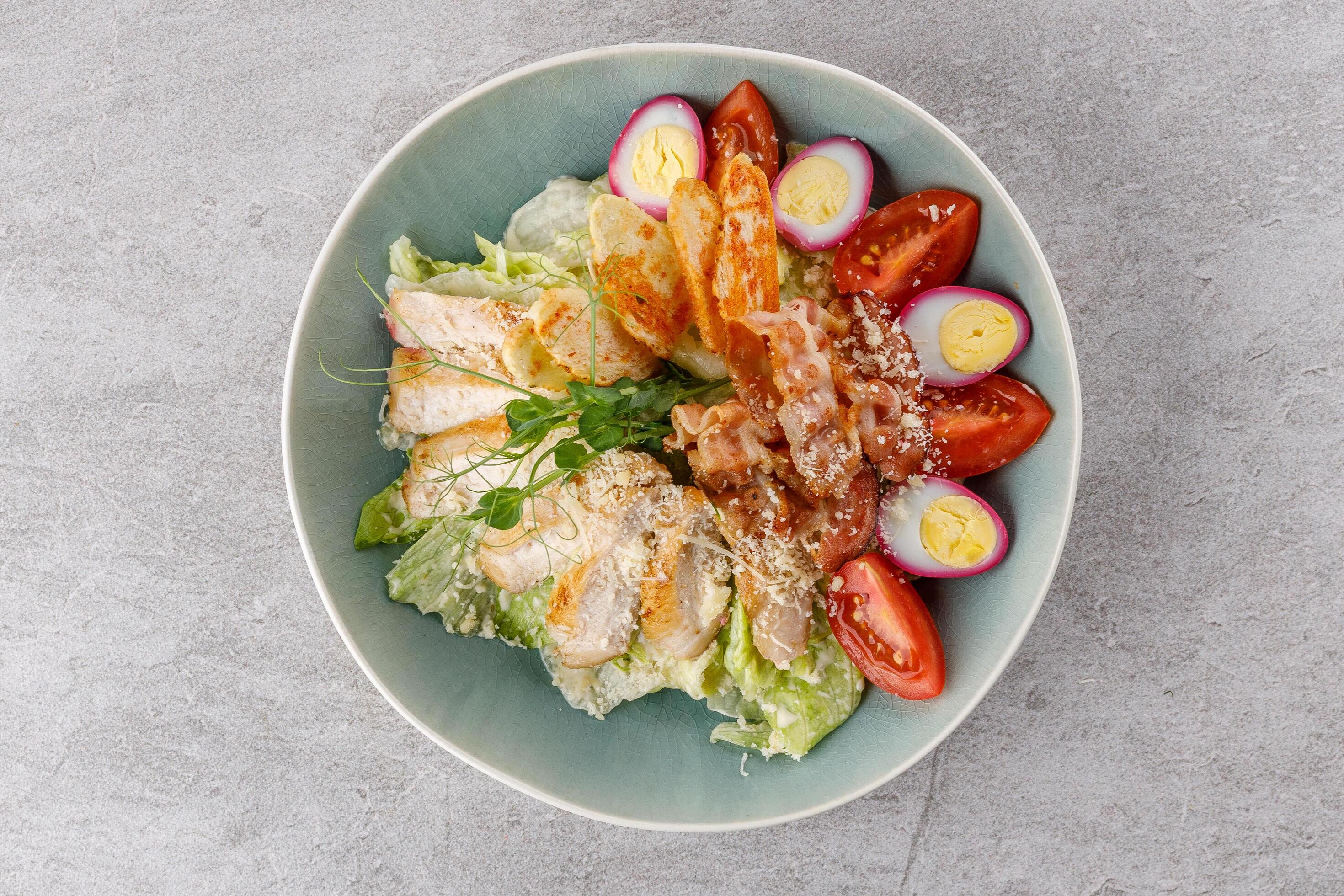 
									Caesar salad with chicken and bacon on a stone background studio food photo 4 Stock Free