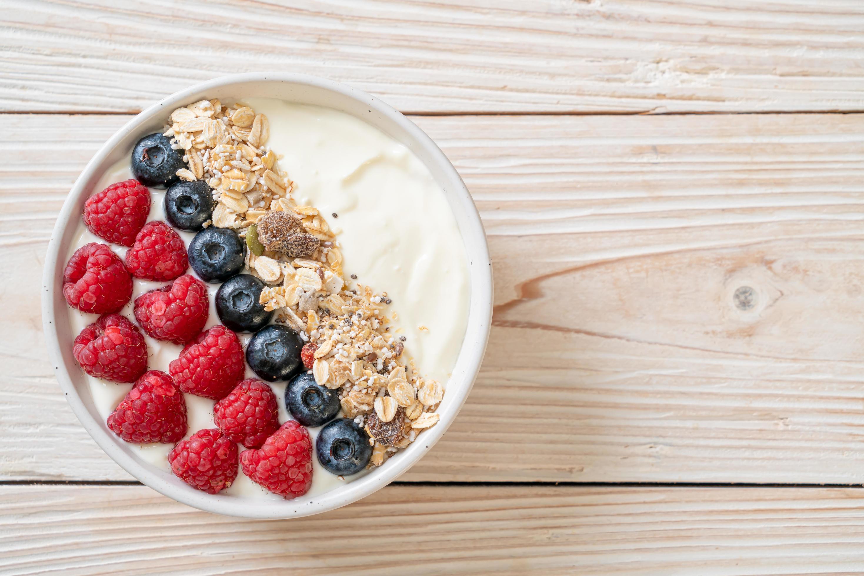 Homemade yogurt bowl with raspberry, blueberry and granola – healthy food style Stock Free