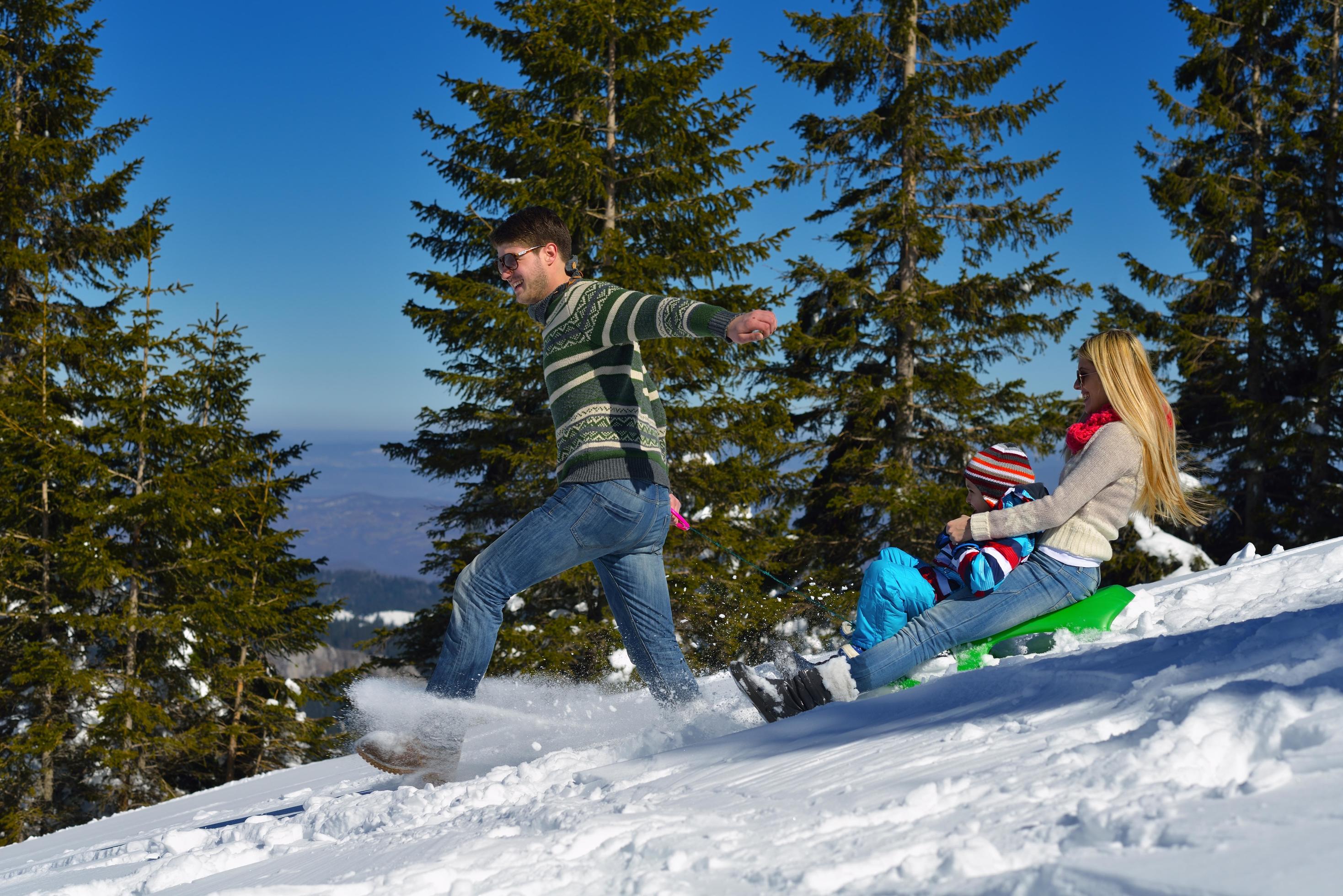 family having fun on fresh snow at winter vacation Stock Free