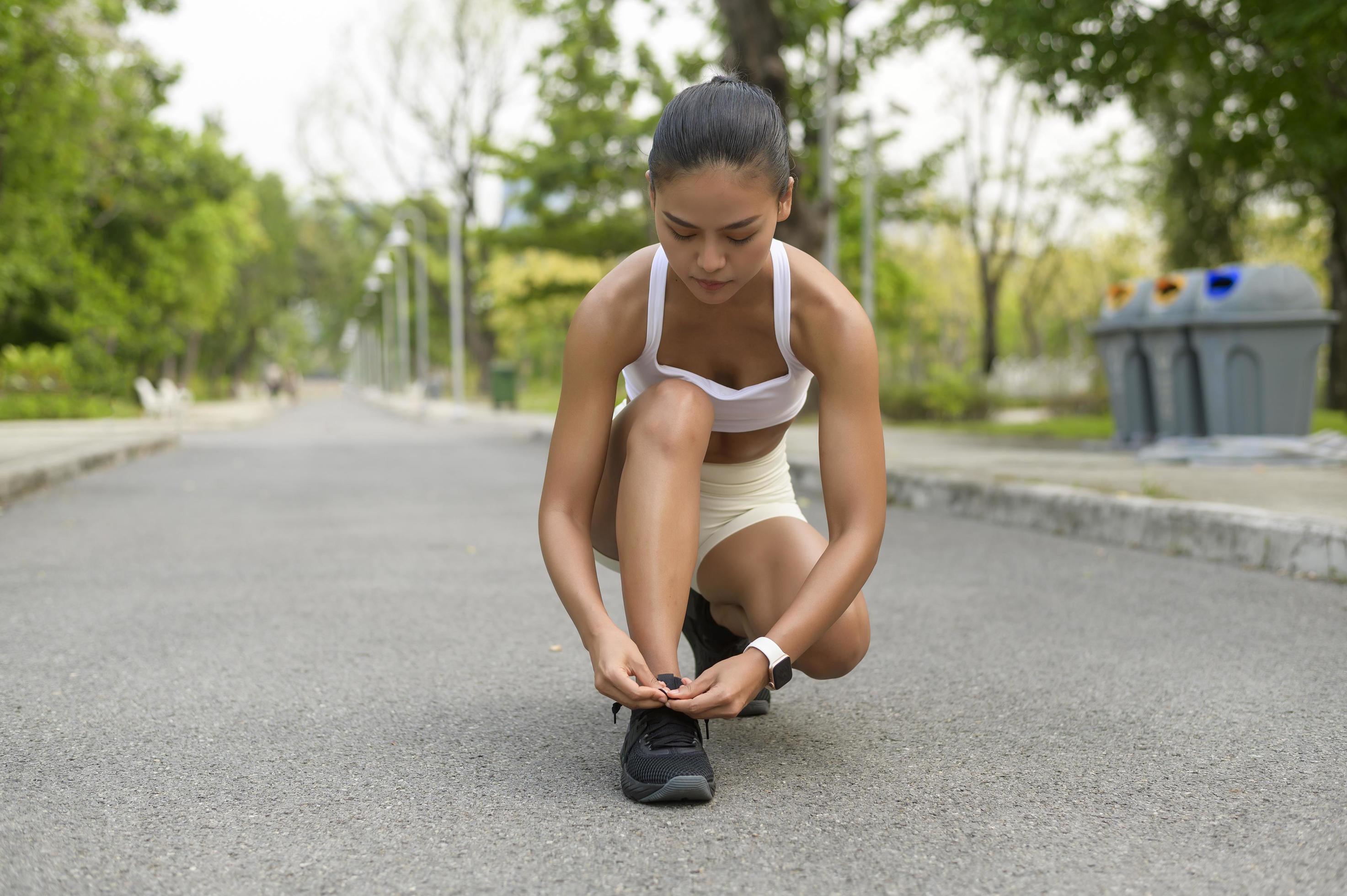 Young fitness woman in sportswear tying shoelace in city park, Healthy and Lifestyles. Stock Free