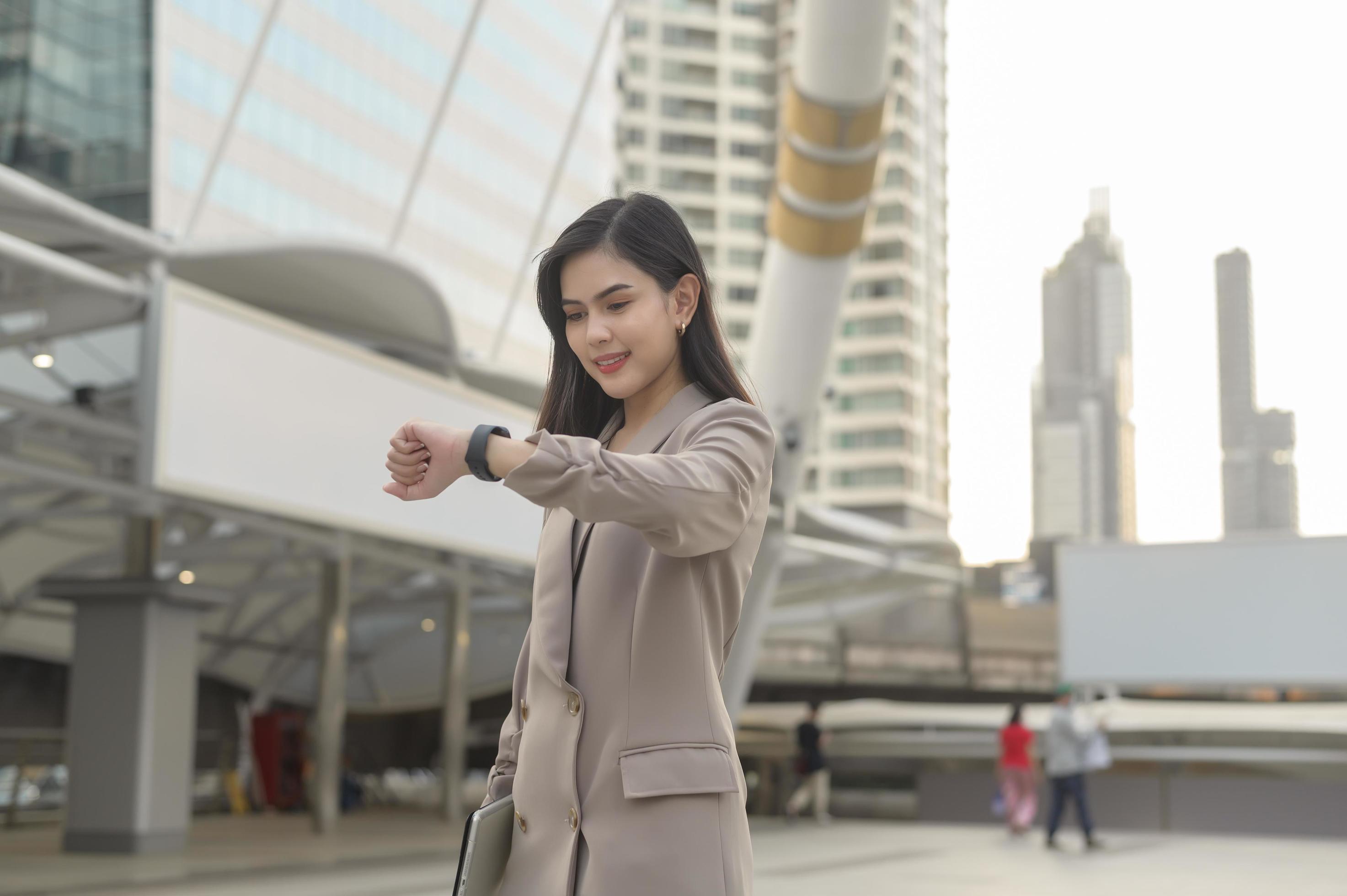 Businesswoman is using Smart watch in Modern city , business technology , city lifestyle concept Stock Free