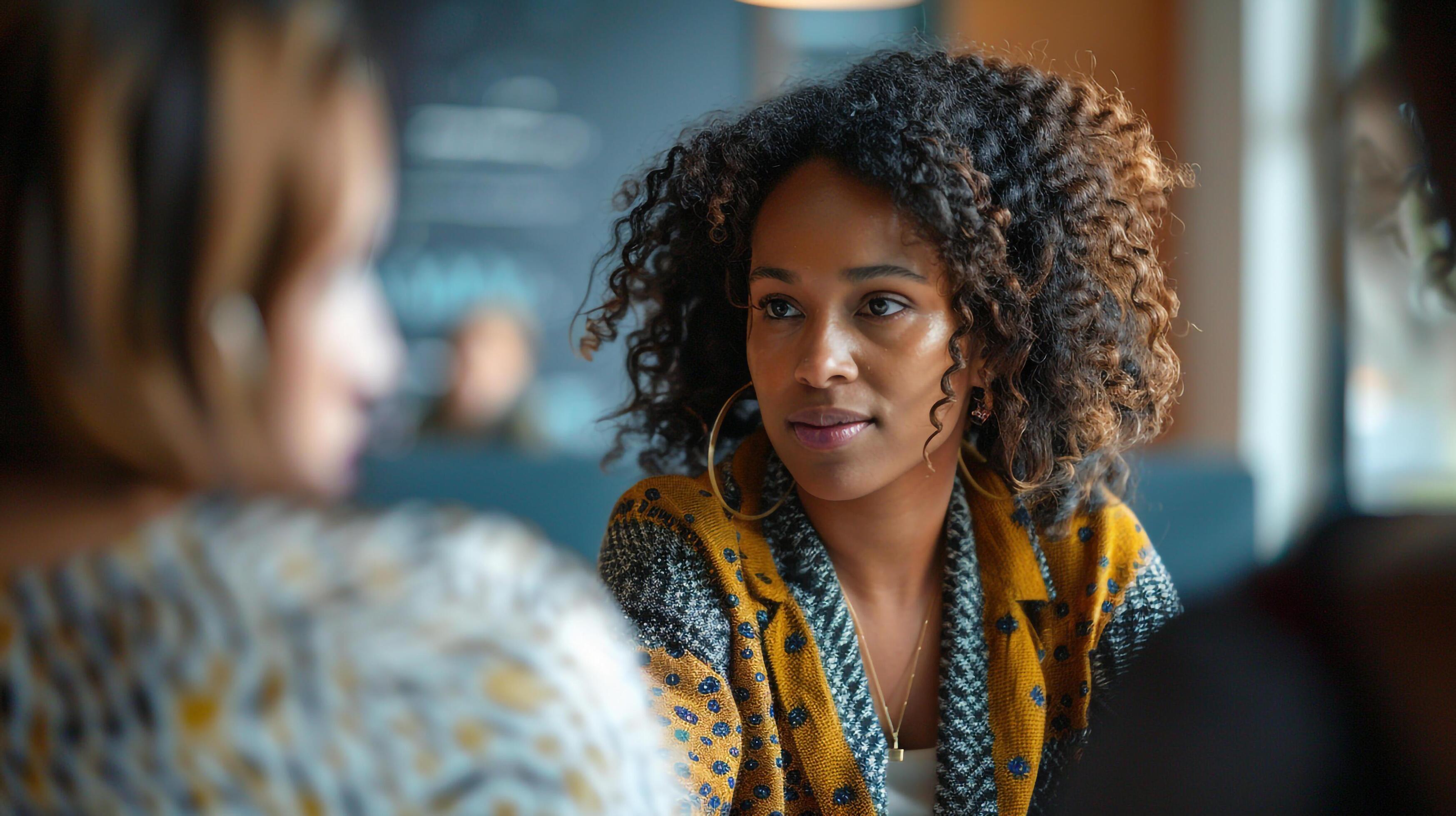 Curly-haired woman chatting in cafe Stock Free