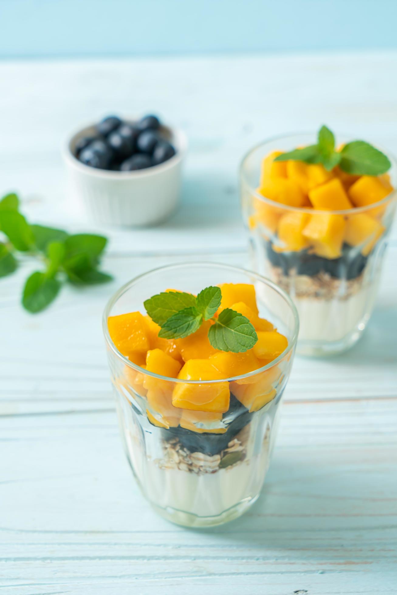 Homemade fresh mango and fresh blueberry with yogurt and granola – healthy food style Stock Free