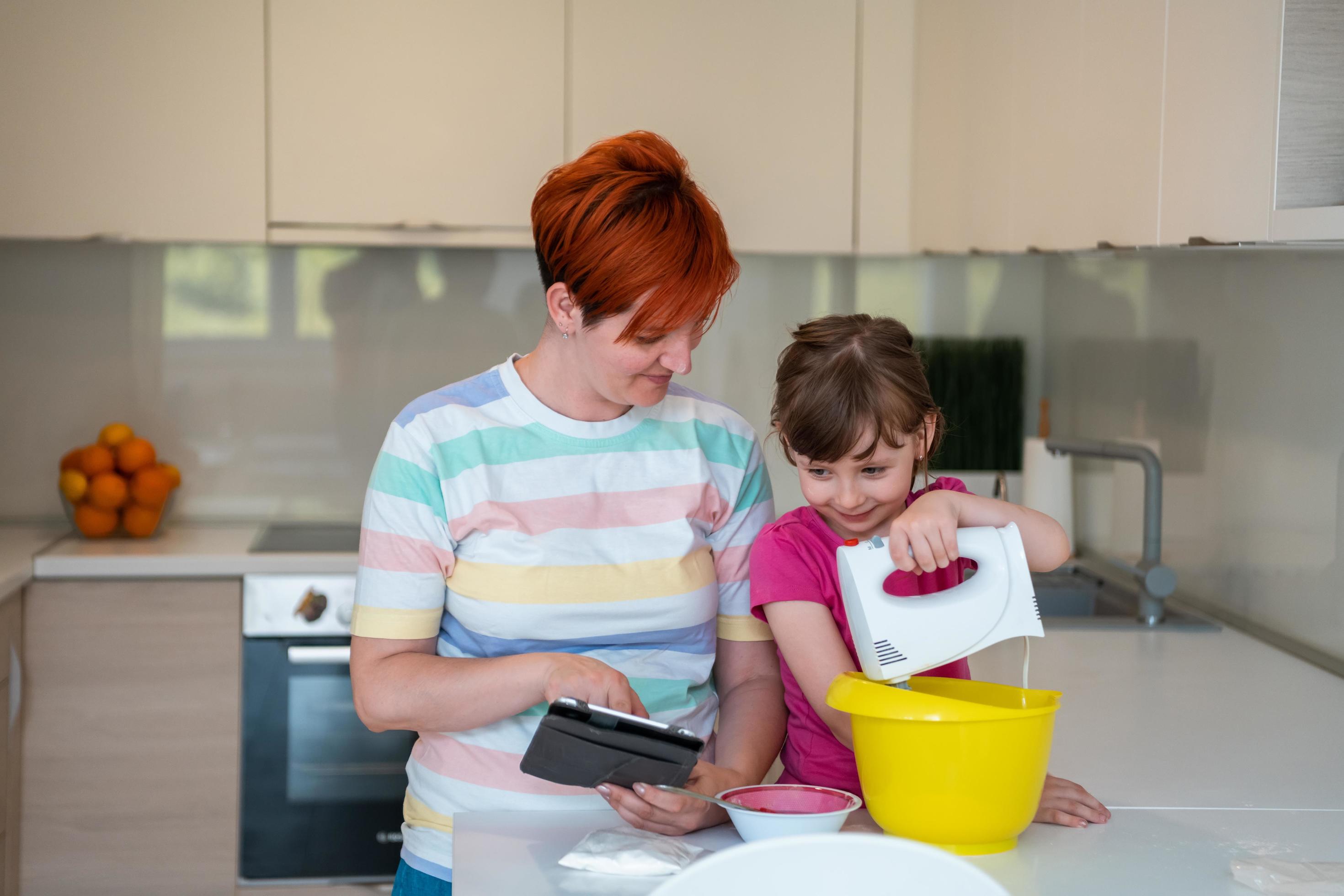 little girl and mom making tastz cake in kithen family having fun at home Stock Free