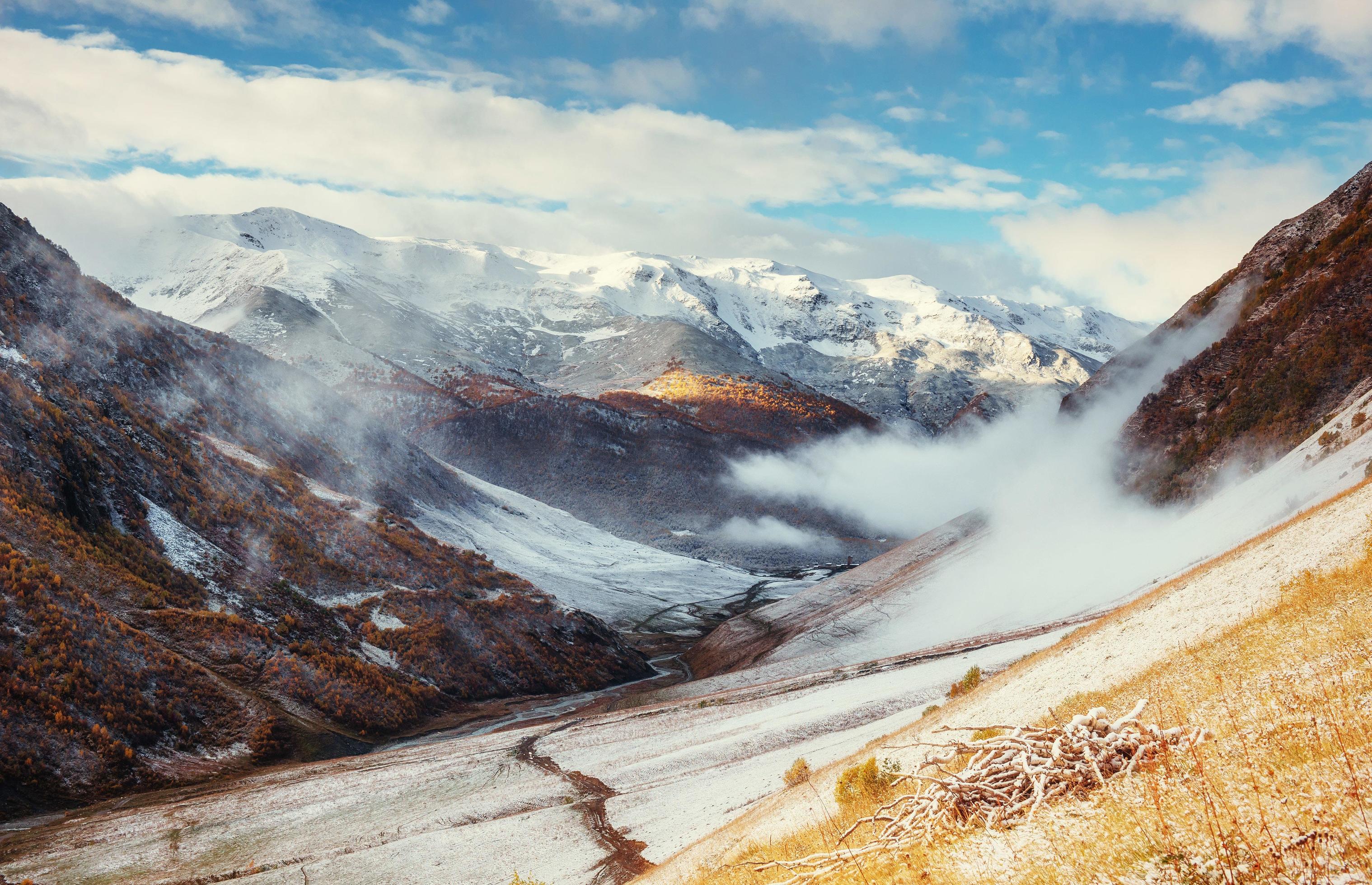 Mountain landscape of snow-capped mountains in the mist Stock Free