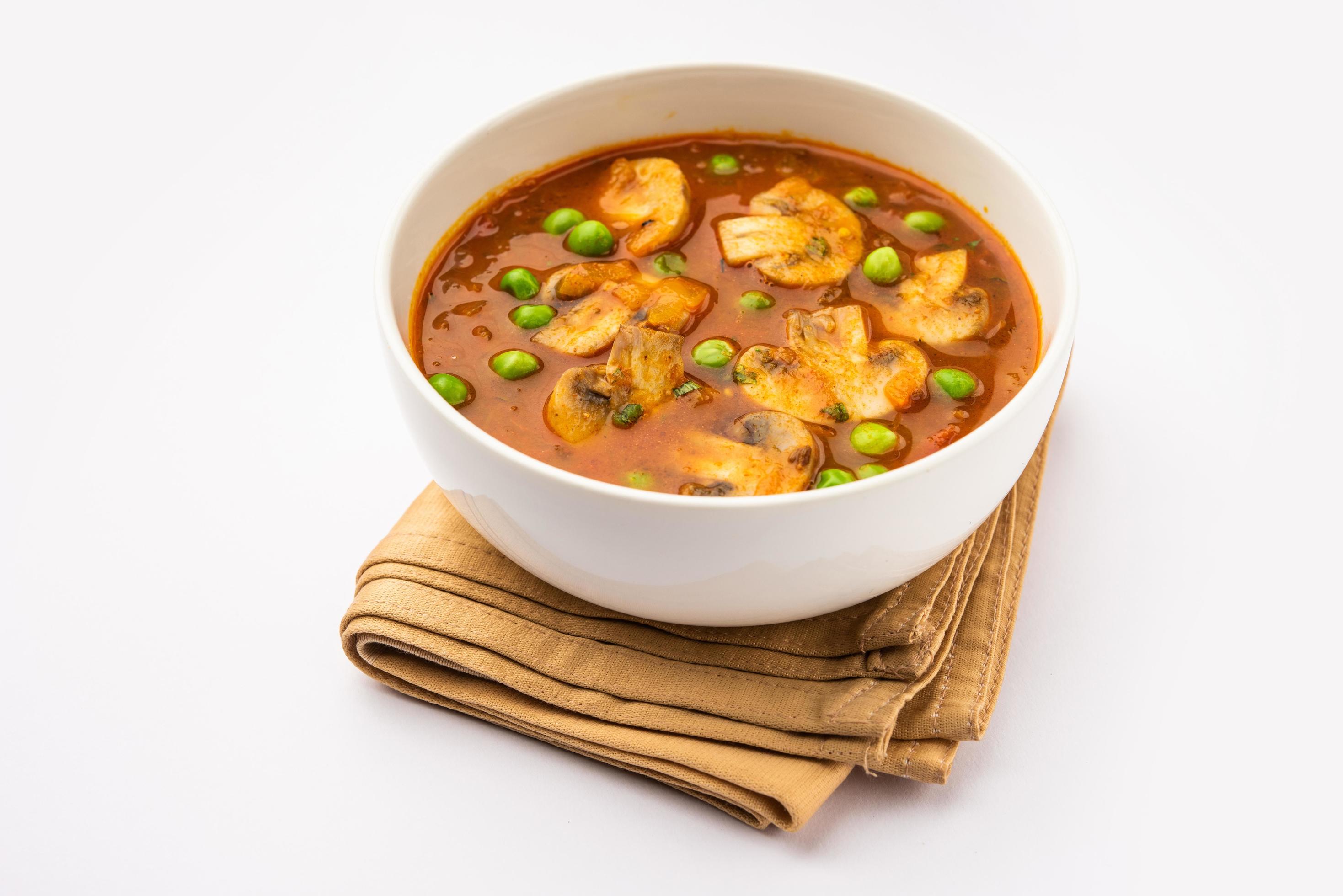 Mushroom and Pea Curry with Roasted Garlic, Indian food served in a bowl Stock Free