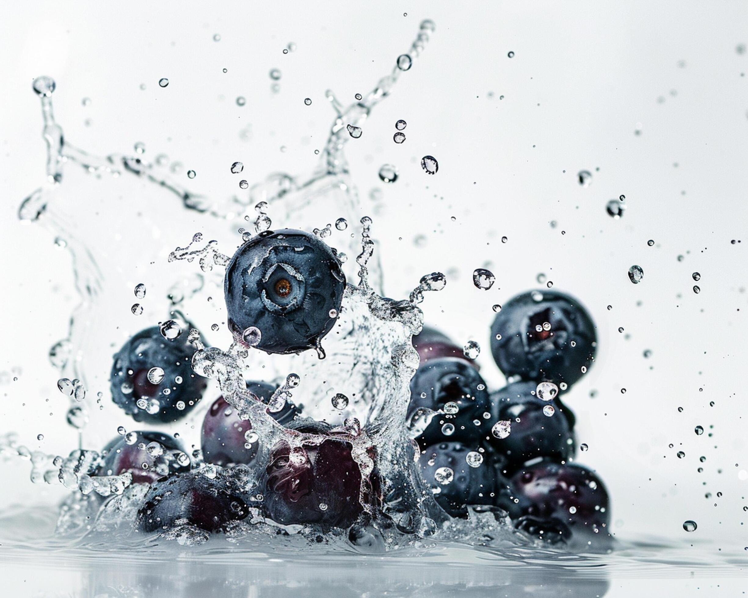 blueberries are splashing into the water Stock Free