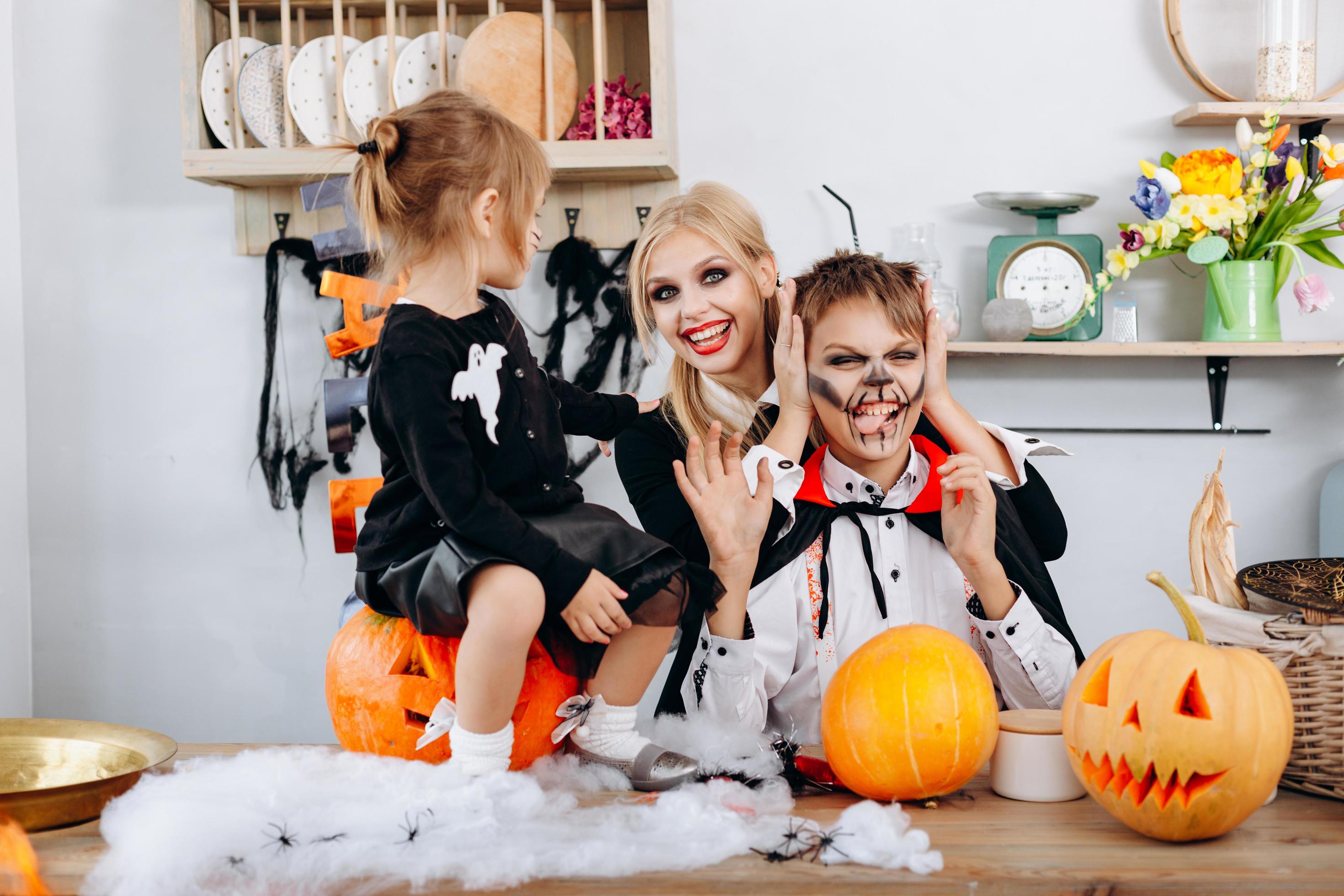 Happy family preparations to Halloween. Boy showing tongue and woman smiling Stock Free