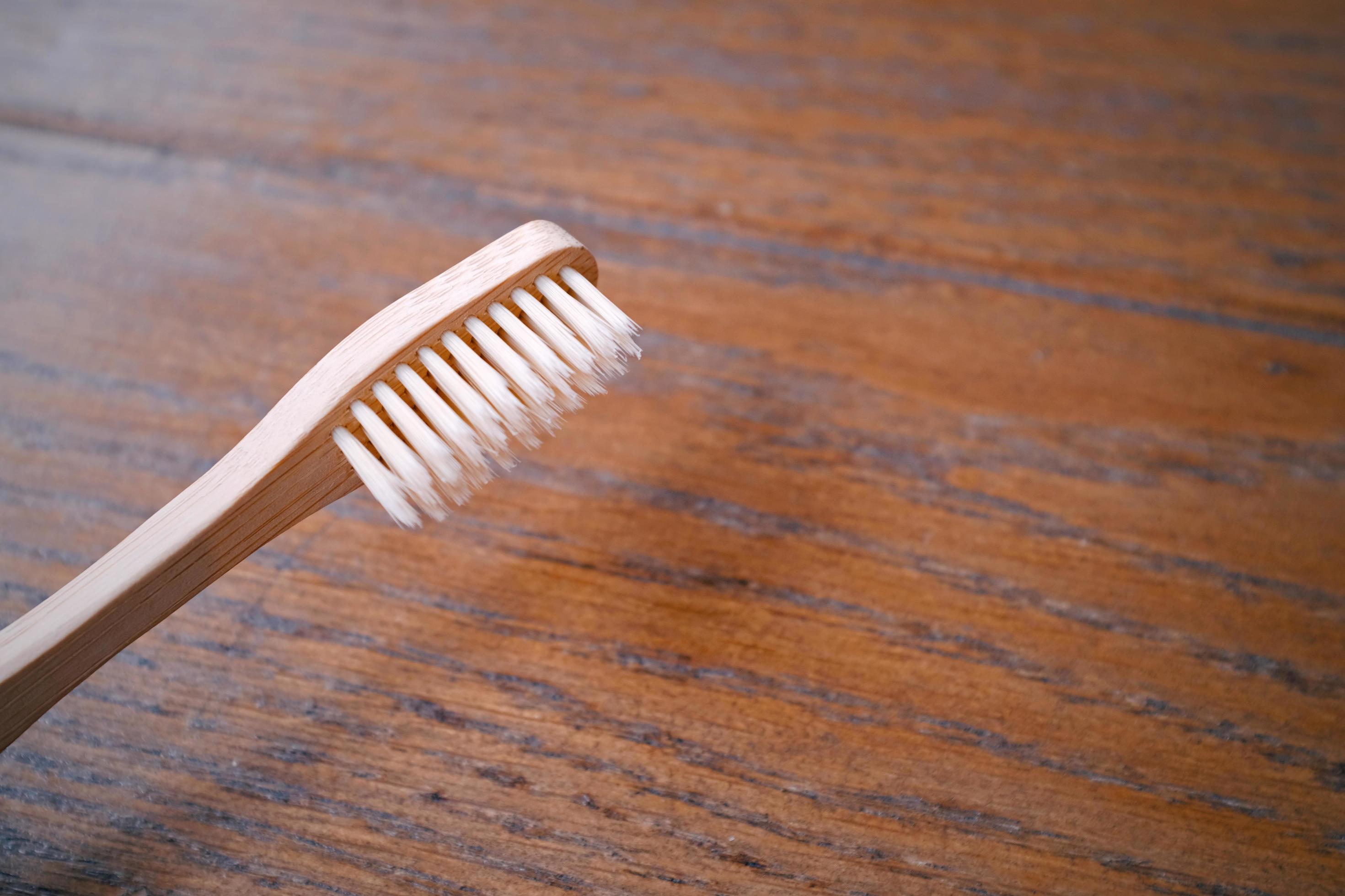 Close up of wooden bamboo toothbrush on wood table with copy space, sustainable lifestyle, zero waste concept Stock Free