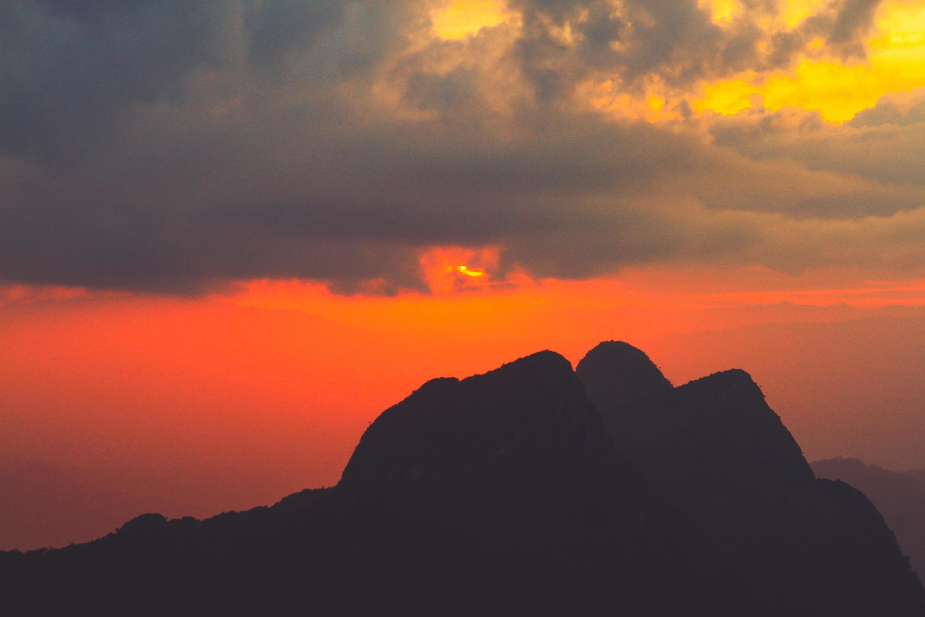 Sunset in sky and cloud, beautiful colorful twilight time with silhouette of mountain. Stock Free