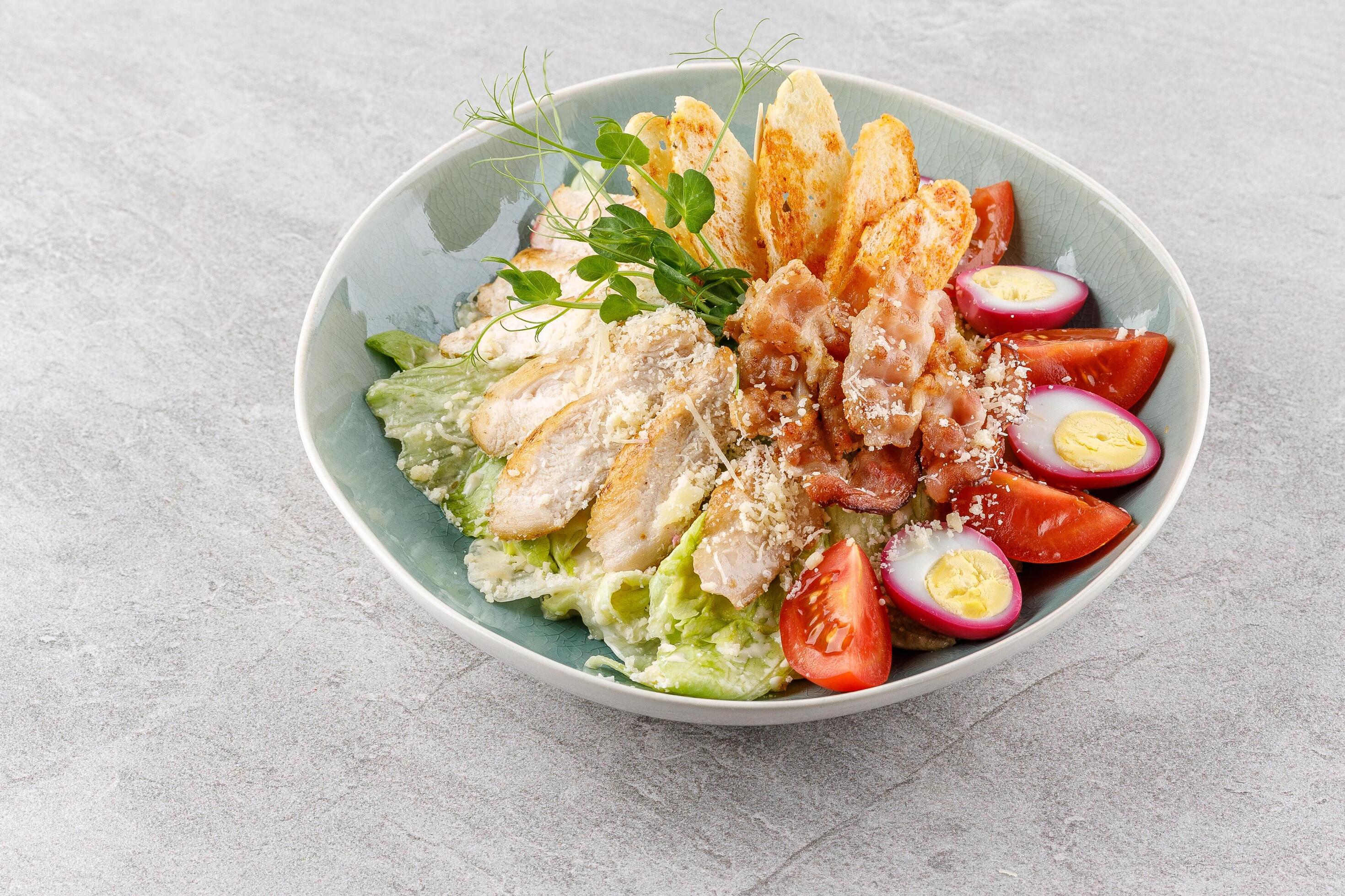 Caesar salad with chicken and bacon on a stone background studio food photo 2 Stock Free