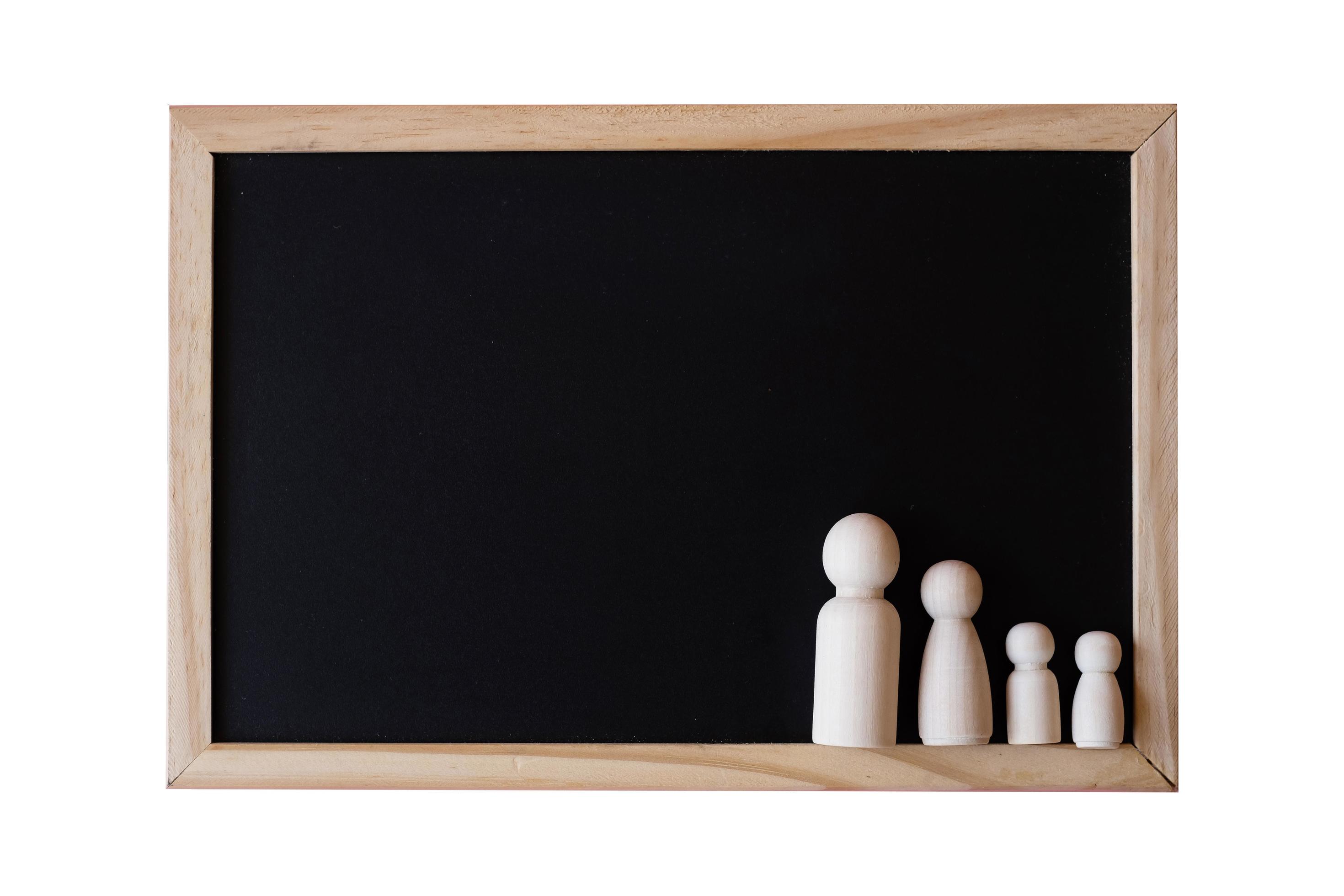 Wooden figurines of family father, mother and children on the black board on white background. copy space for text. Stock Free