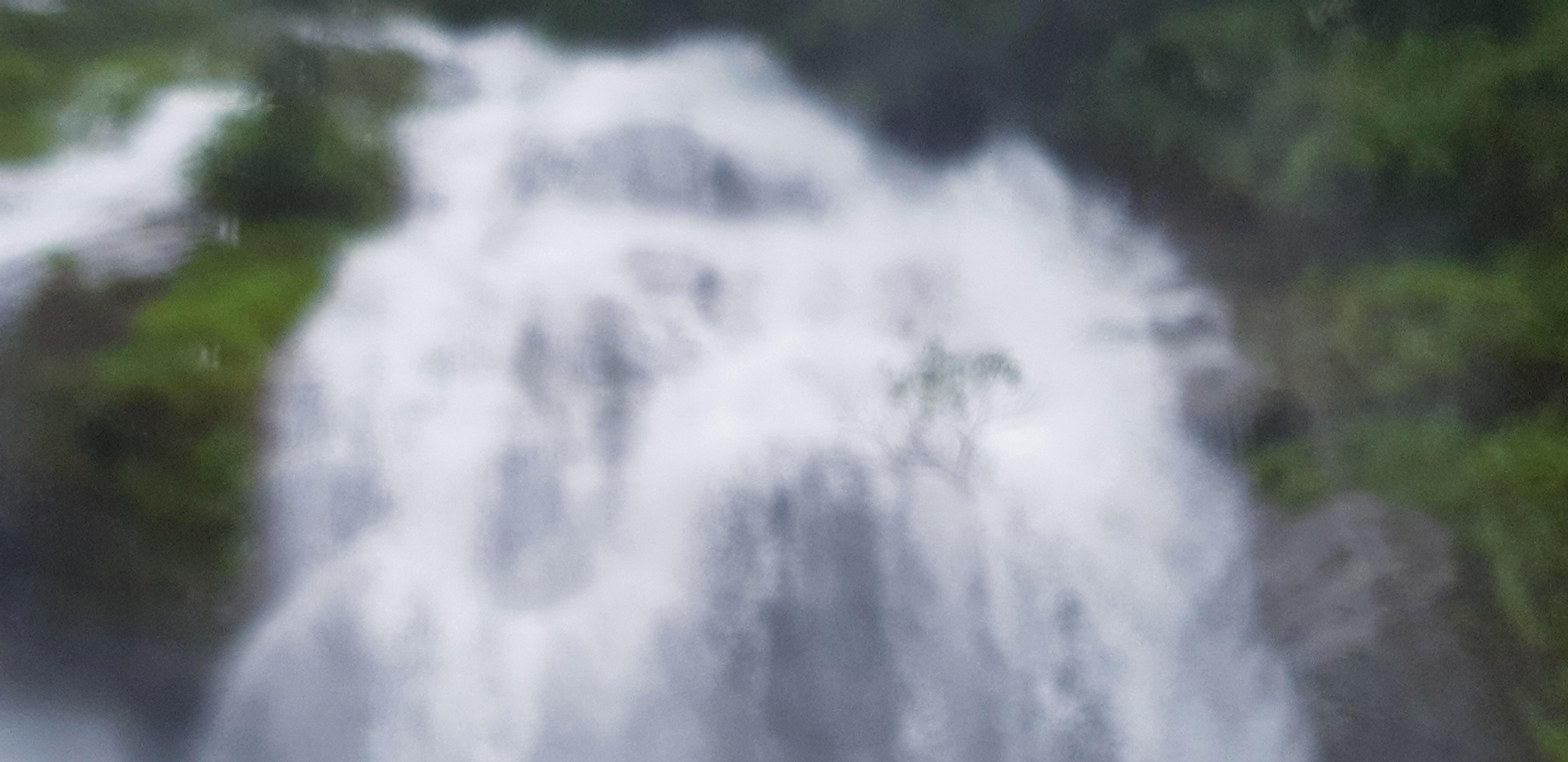 Blurred waterfall with green tree, forest background at Thailand. Natural wallpaper in tropical jungle concept. Stock Free