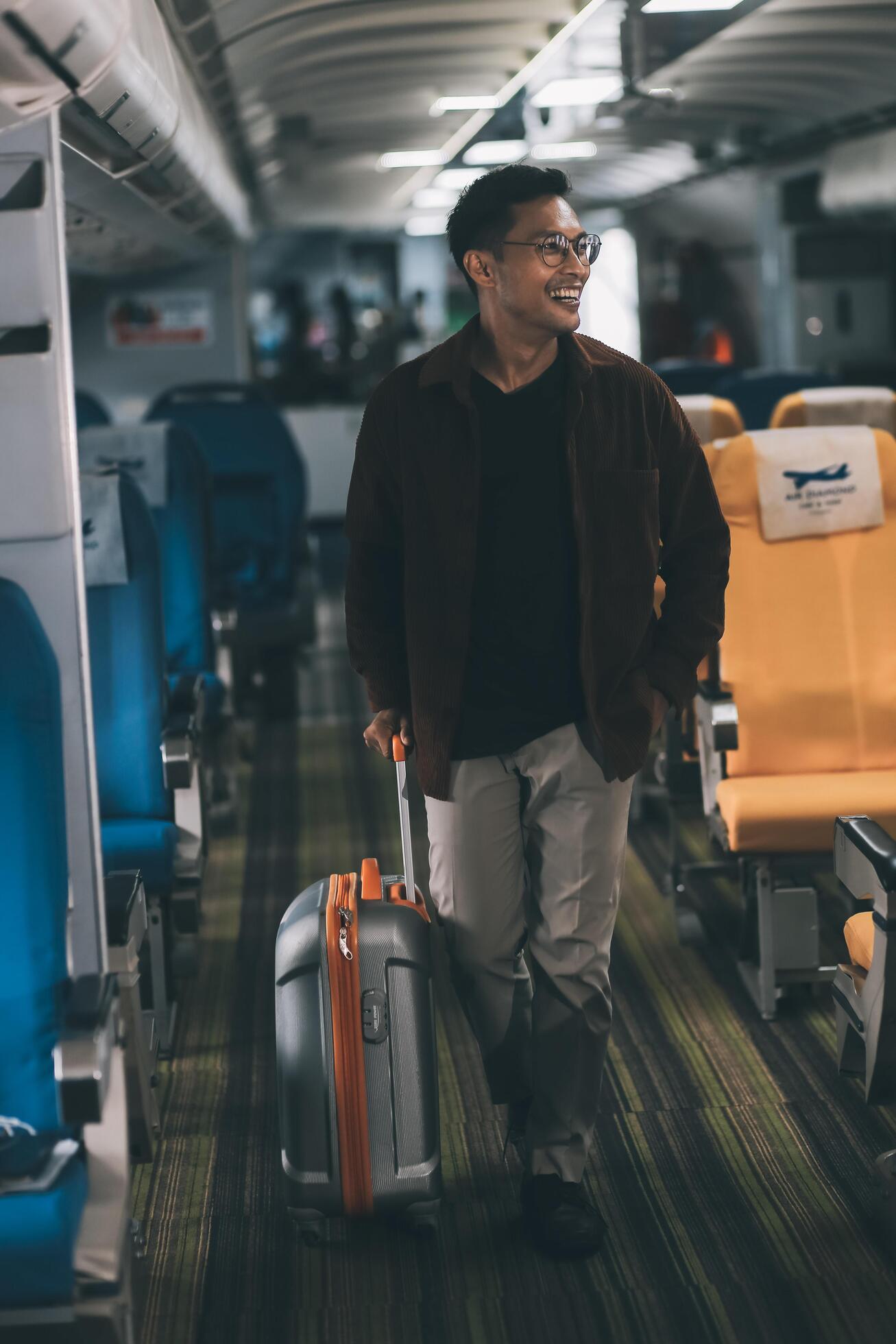 Low Section of Passenger Businessman Walking with Suitcase at the Entrance Walkway in Airport. Focus on Luggage. Low Angle View Stock Free