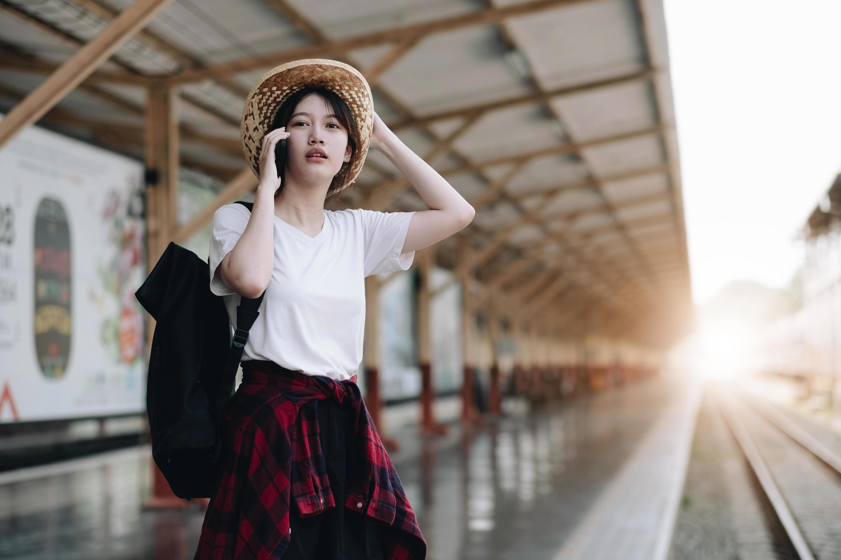 Young traveler woman looking for friend planning trip at train station. Summer and travel lifestyle concept Stock Free