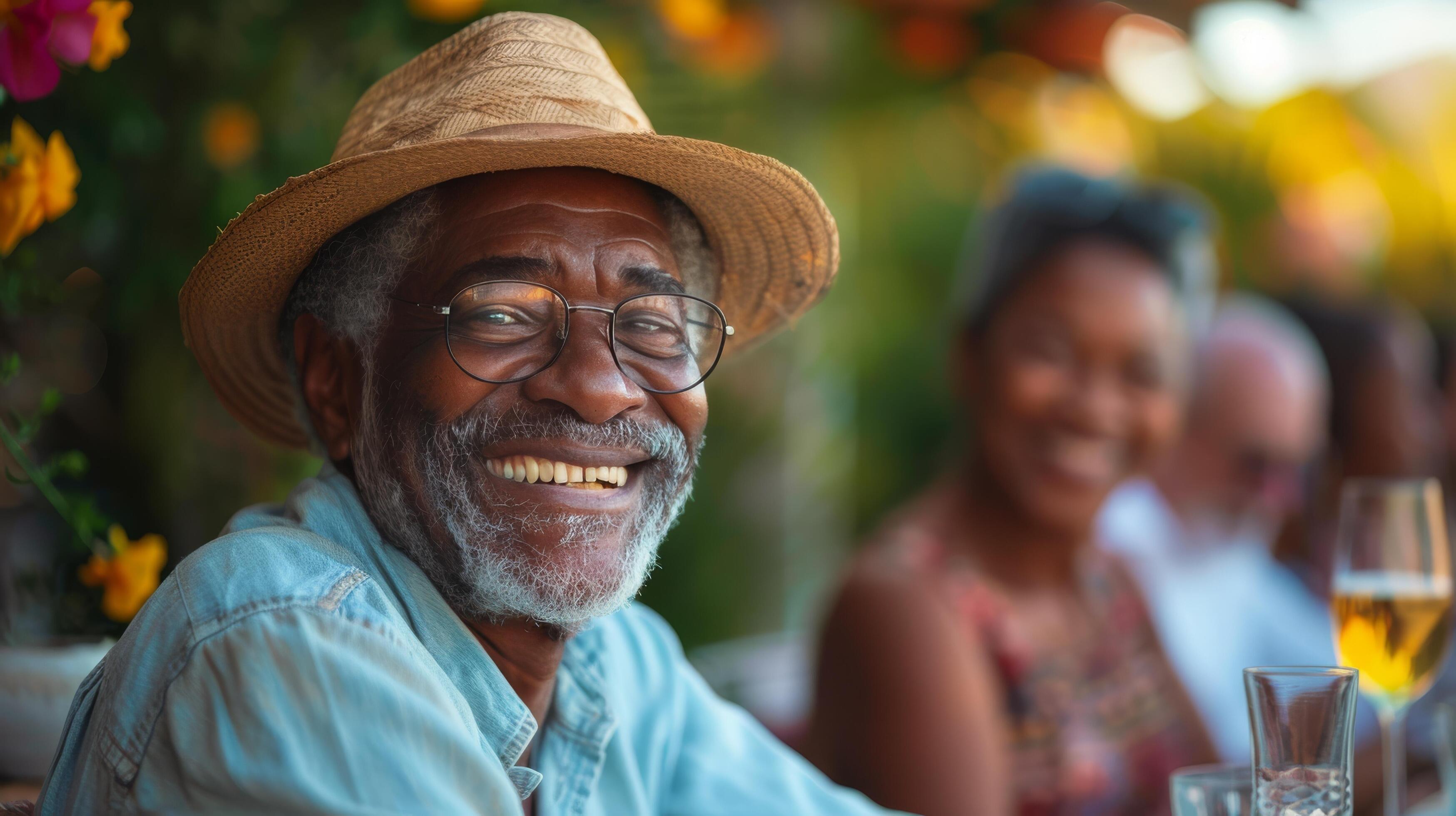 Happy Senior Man Wearing a Straw Hat Smiles Outdoors in the Daylight Stock Free