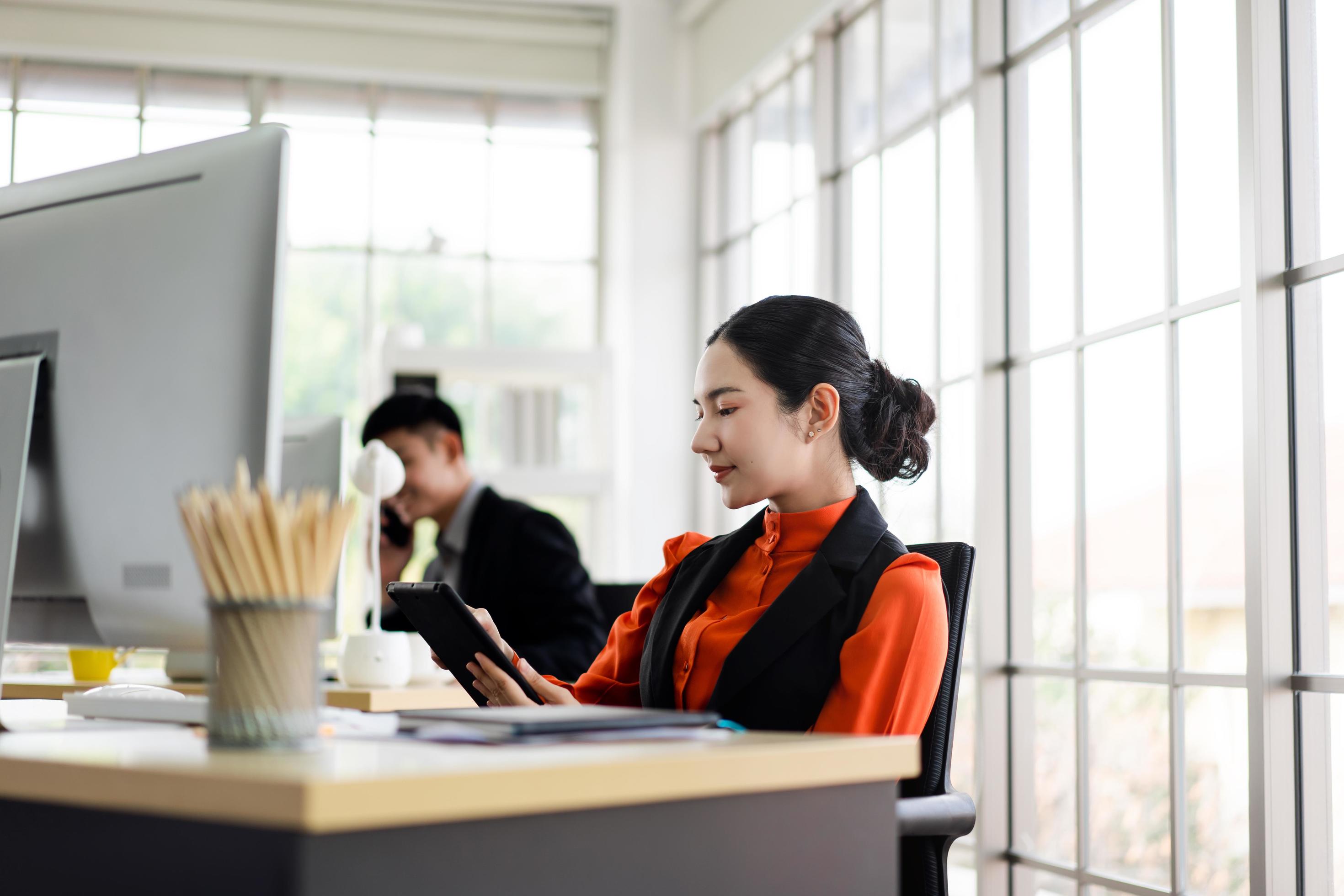 Young adult asian business woman using tablet in office. Stock Free