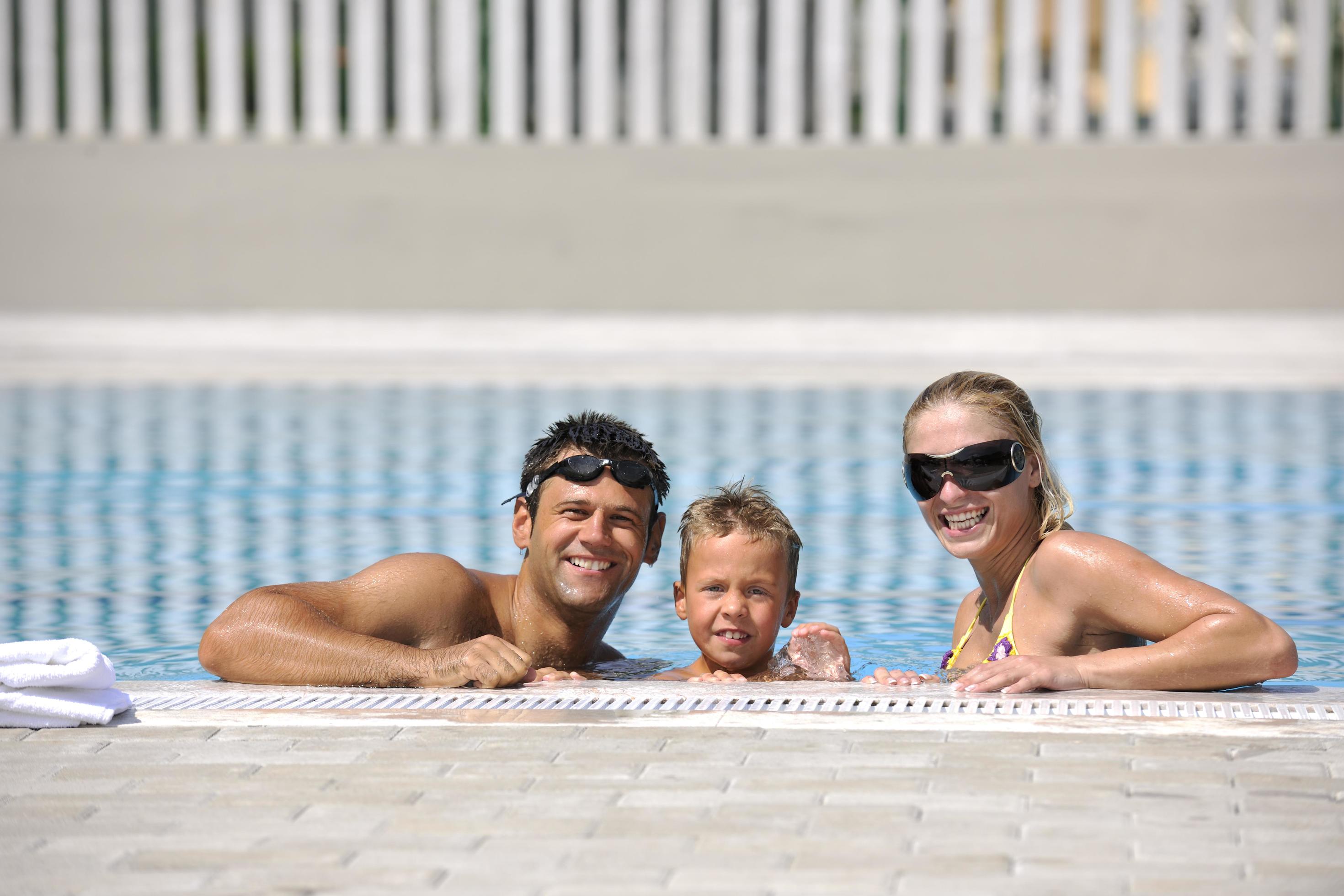 happy young family have fun on swimming pool Stock Free