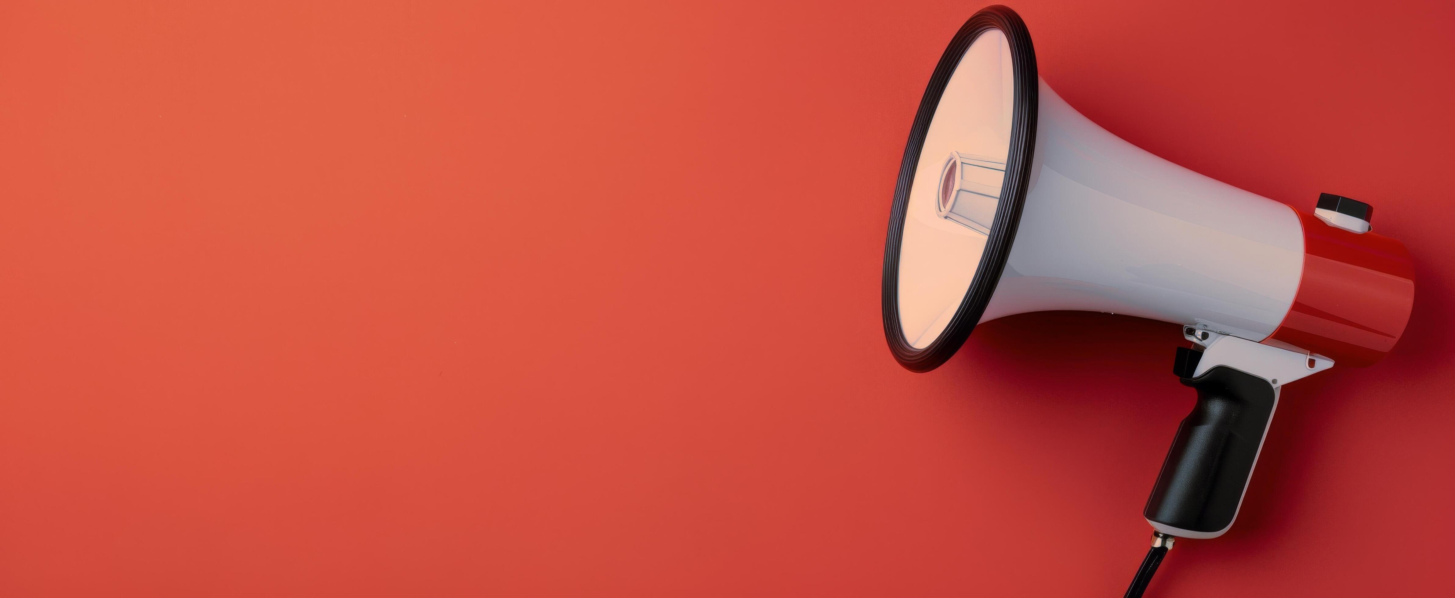 Megaphone Positioned on Red Background for Announcements and Communication Stock Free