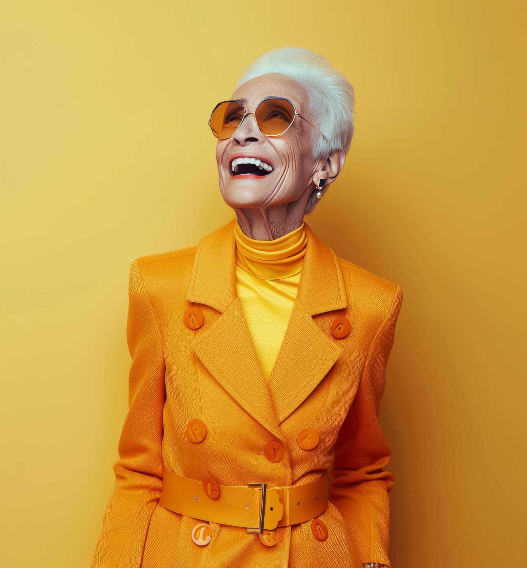 Smiling Senior Woman In Yellow Coat And Sunglasses Against Yellow Background Stock Free