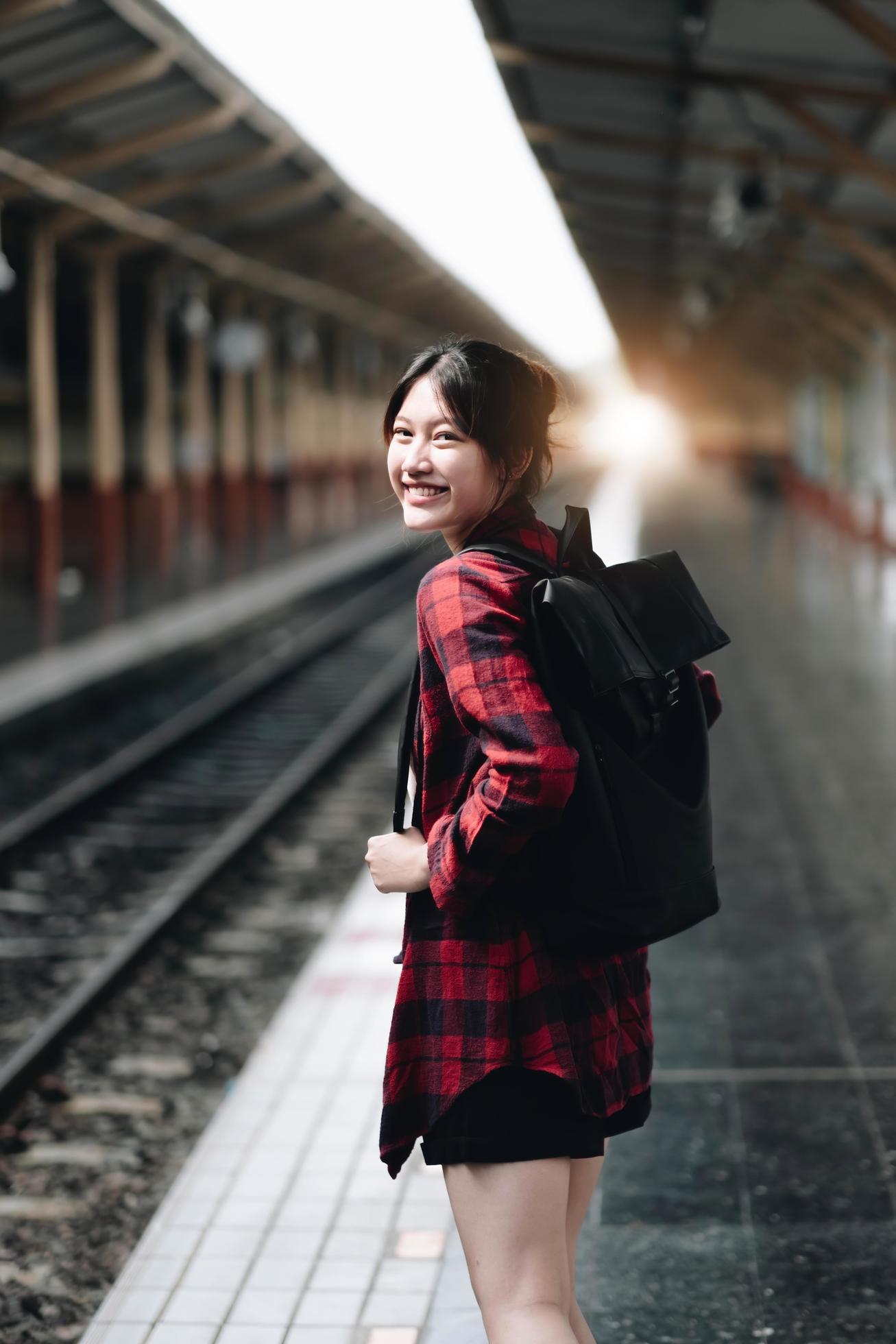 Young traveler woman looking for friend planning trip at train station. Summer and travel lifestyle concept Stock Free