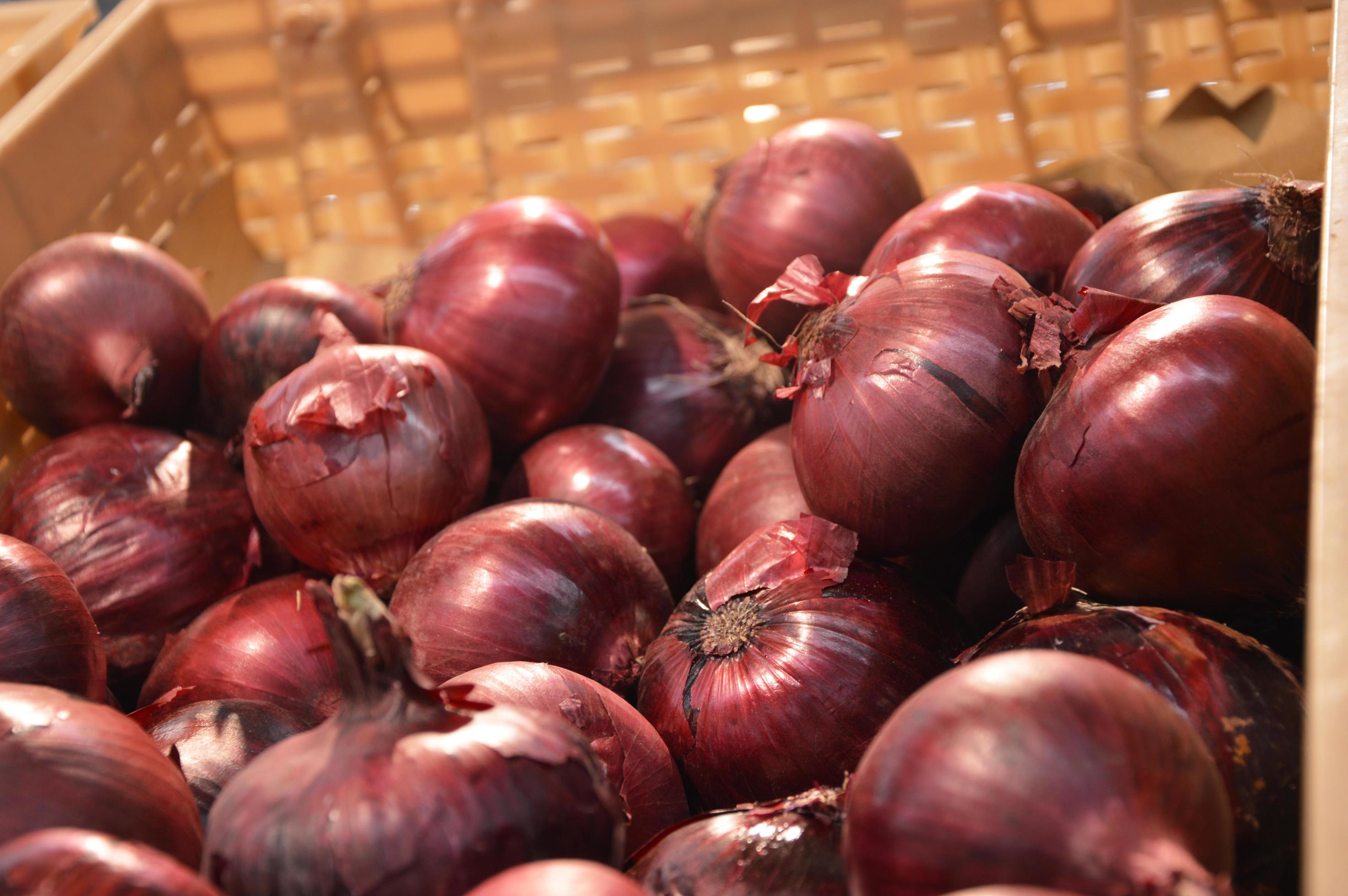 Red onions are on display in abundance on the supermarket counter. Fresh vegetables, harvesting. Vegetarian food. Stock Free