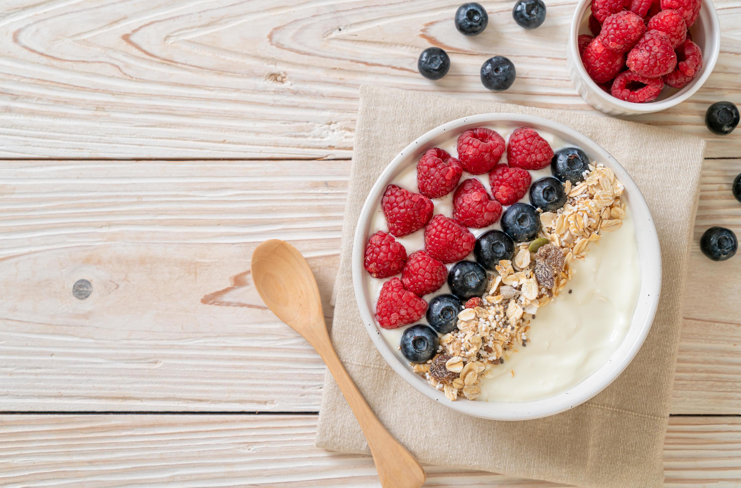 Homemade yogurt bowl with raspberry, blueberry and granola – healthy food style Stock Free