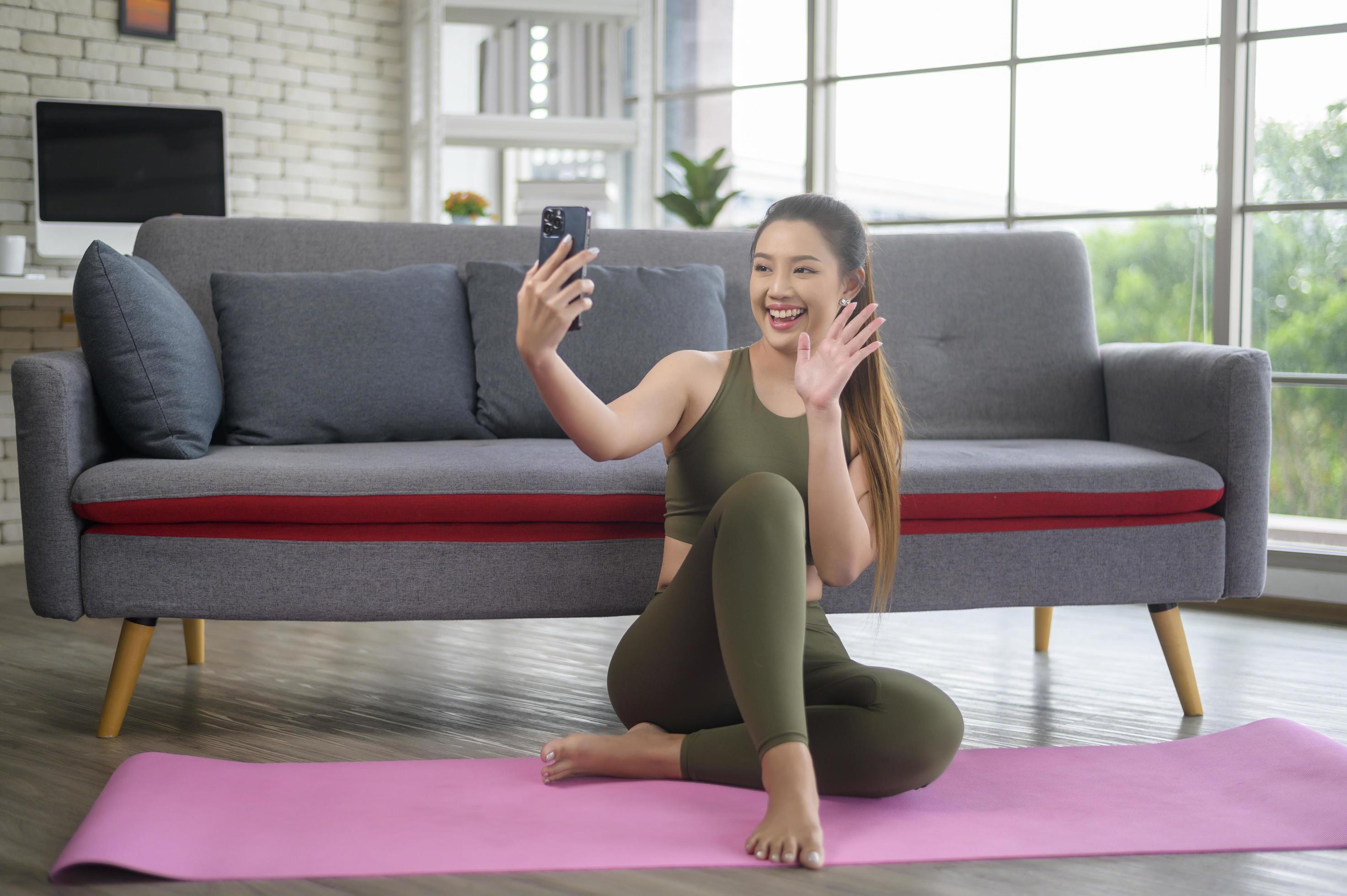 Young fitness woman in sportswear using smart phone while exercising at home, Healthy and Lifestyles. Stock Free